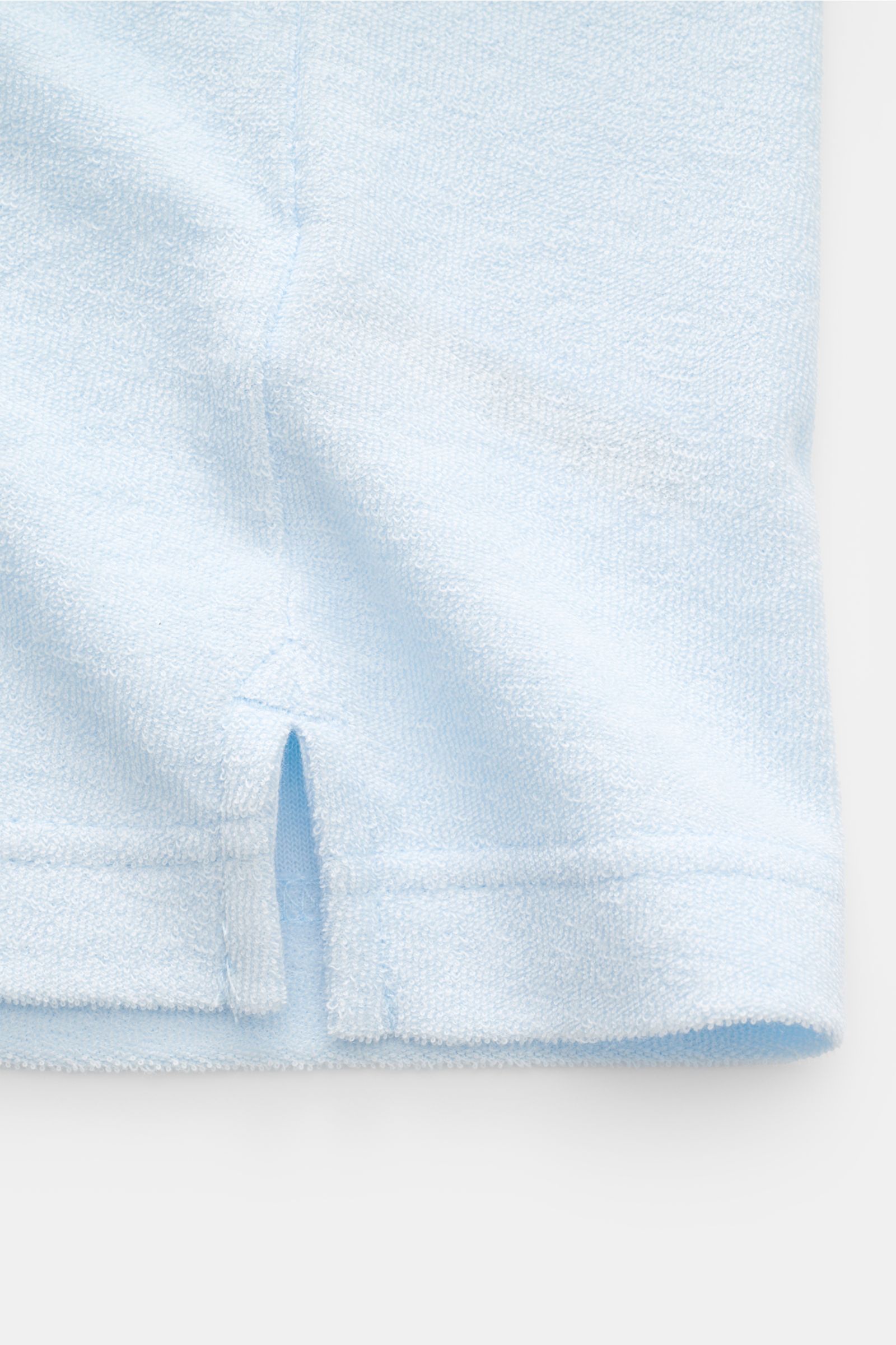 Nahaufnahme des Saumdetails mit kurzen Saumschlitzen des pastellblauen MC2 Saint Barth Frottee-Poloshirts 'Jeremy' aus weichem Lyocell-Baumwoll-Mix.