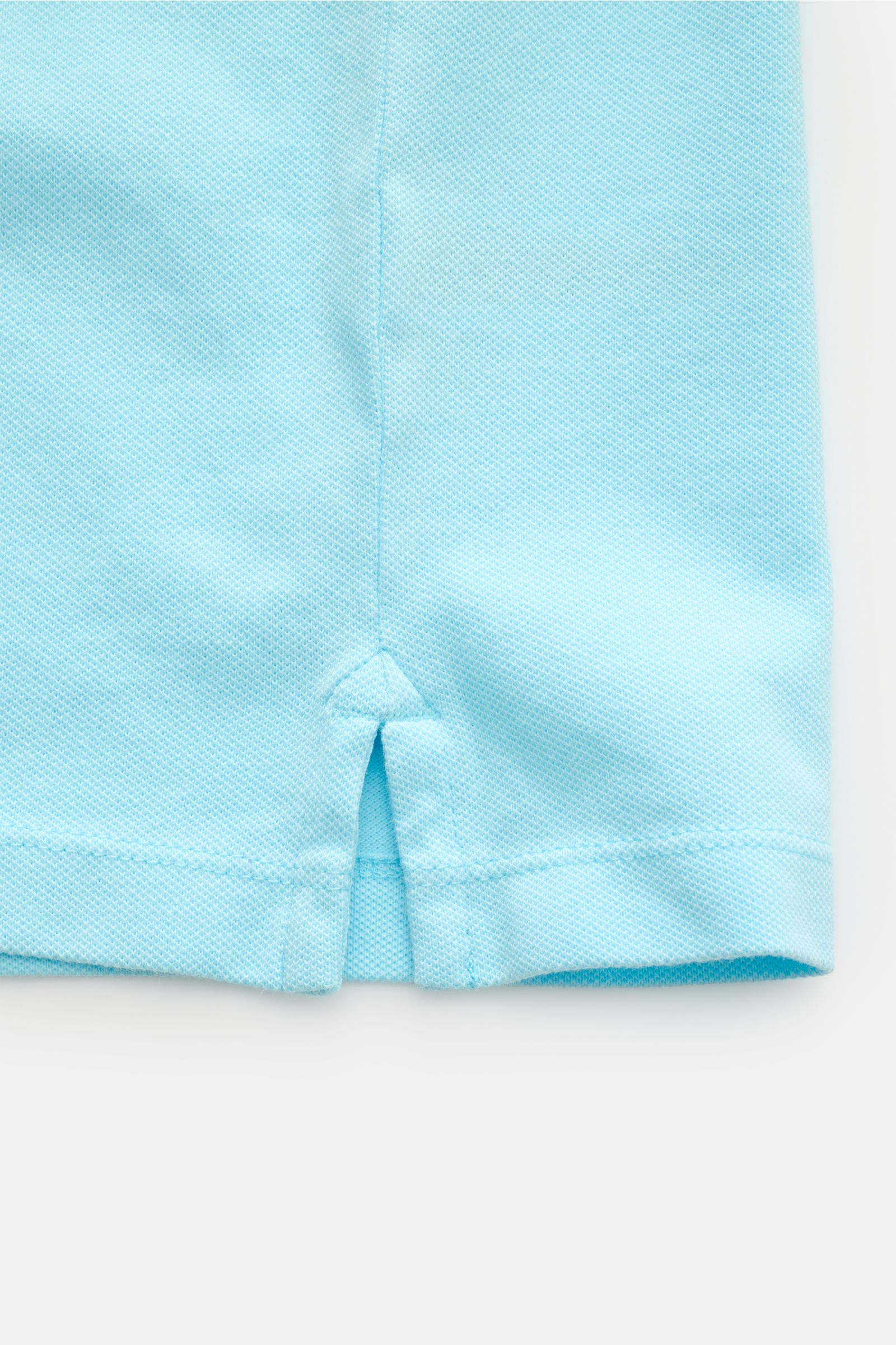 Close-up view of the hem detail of the MC2 Saint Barth Poloshirt 'Charles' türkis, showing turquoise elastic cotton piqué fabric, soft texture, slim fit, and short side slits