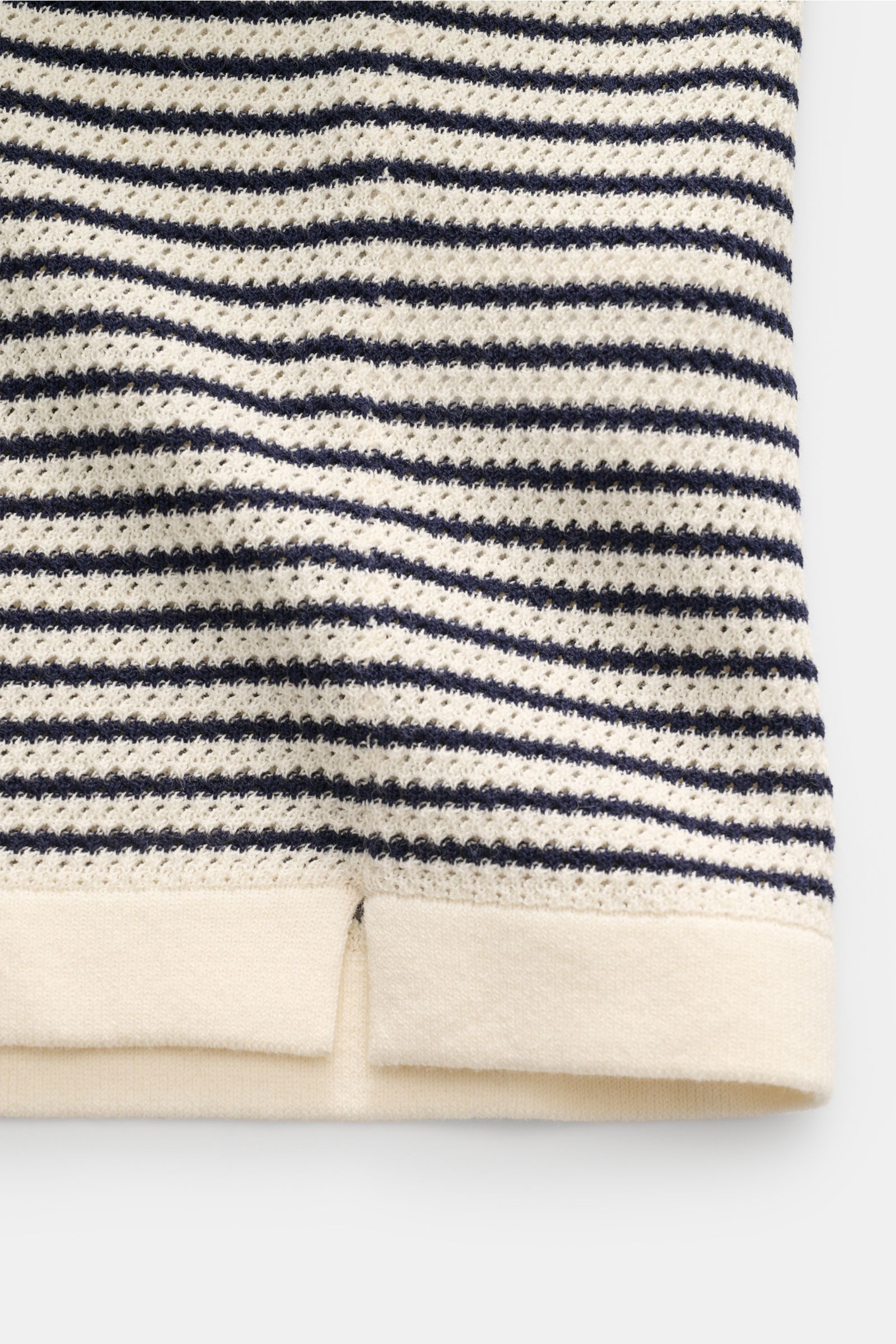 Close-up, front view of the bottom hem of the MC2 Saint Barth Short sleeve knit polo 'Sloan' cream/navy striped, showing fine textured knit and short hem vents.

Light and summery: This knit polo shirt by 