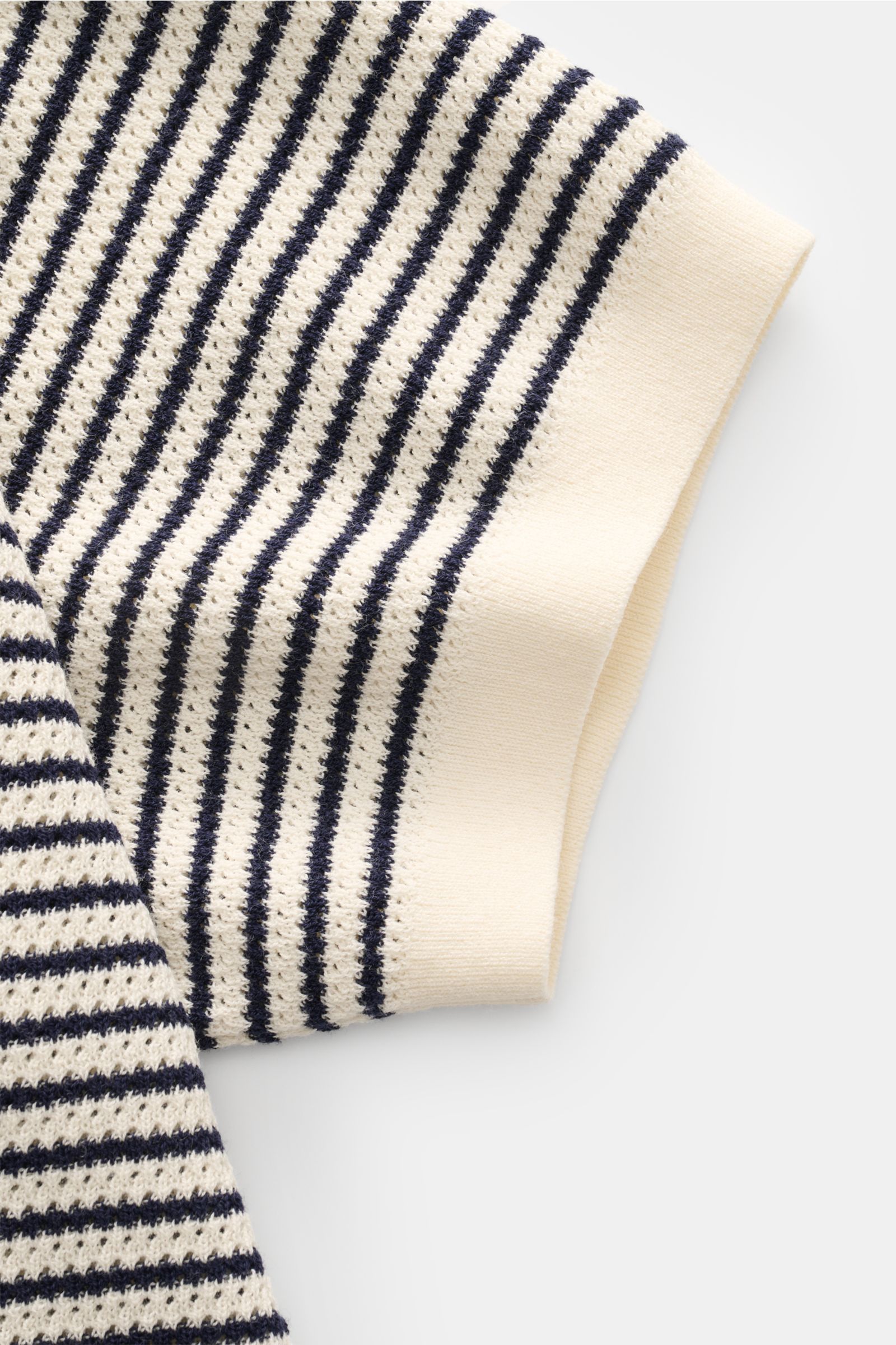Close-up of the sleeve of the MC2 Saint Barth Short sleeve knit polo 'Sloan' cream/navy striped, showing the fine textured knit with navy stripes and cream cuff photographed from above.

Light and summery: This knit polo shirt by 