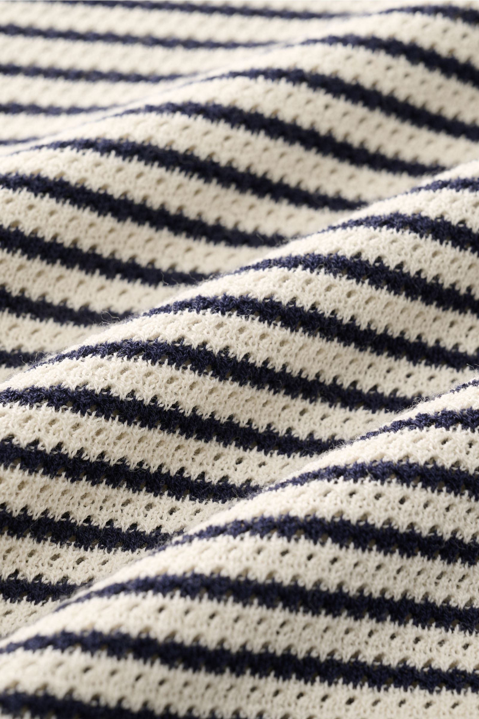 Close-up photo of the striped knit fabric of the MC2 Saint Barth Short sleeve knit polo 'Sloan' cream/navy striped, showing the fine textured knit and slightly granular texture from a top-down perspective.

Description: Light and summery: This knit pol