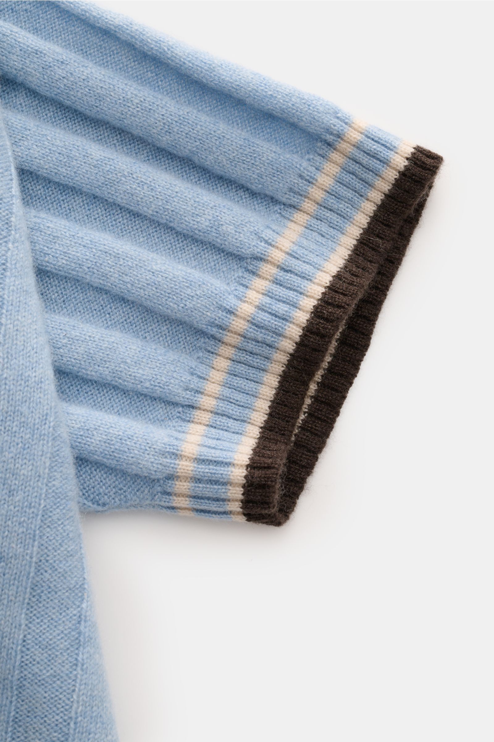 Nahaufnahme des Ärmels vom FTC Cashmere Kurzarm-Strickpolo hellblau mit breitem Rippstrick, farblich abgesetzten Streifen und flexiblem Rippbündchen.