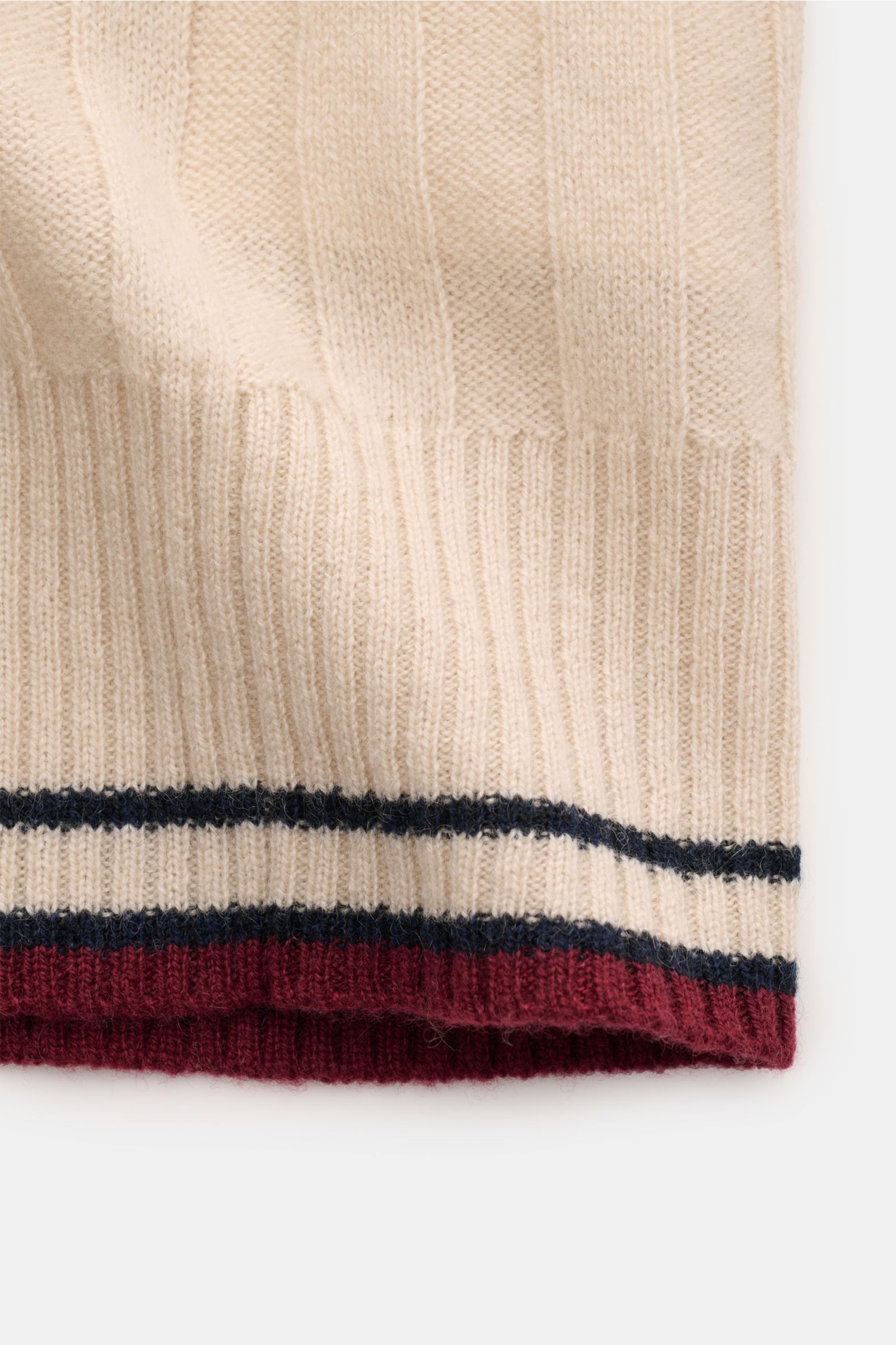 FTC Cashmere Kurzarm-Strickpolo beige in Nahaufnahme von unten, breites Rippstrick-Design mit farblich abgesetzten Streifen am Bund.