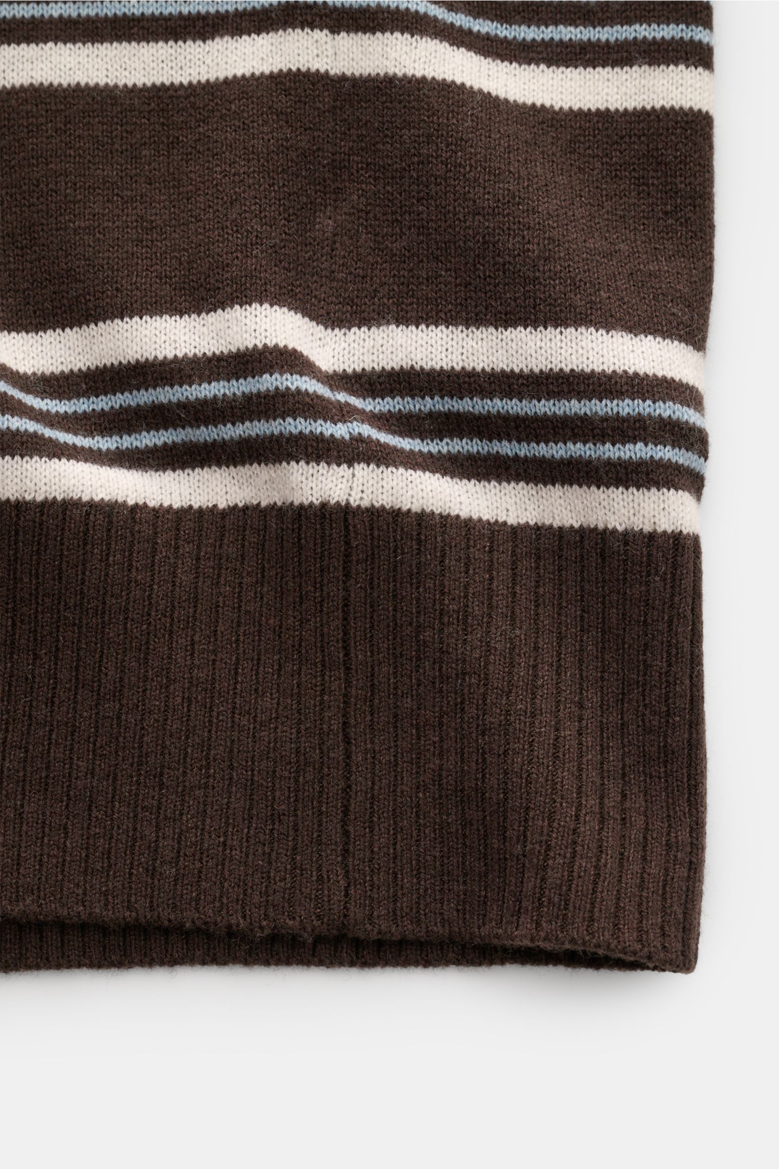 Nahaufnahme des FTC Kurzarm-Strickpolo dunkelbraun/creme/hellblau gestreift von unten mit weichem Griff, feinem Strickbild und flexiblem Rippbündchen.
