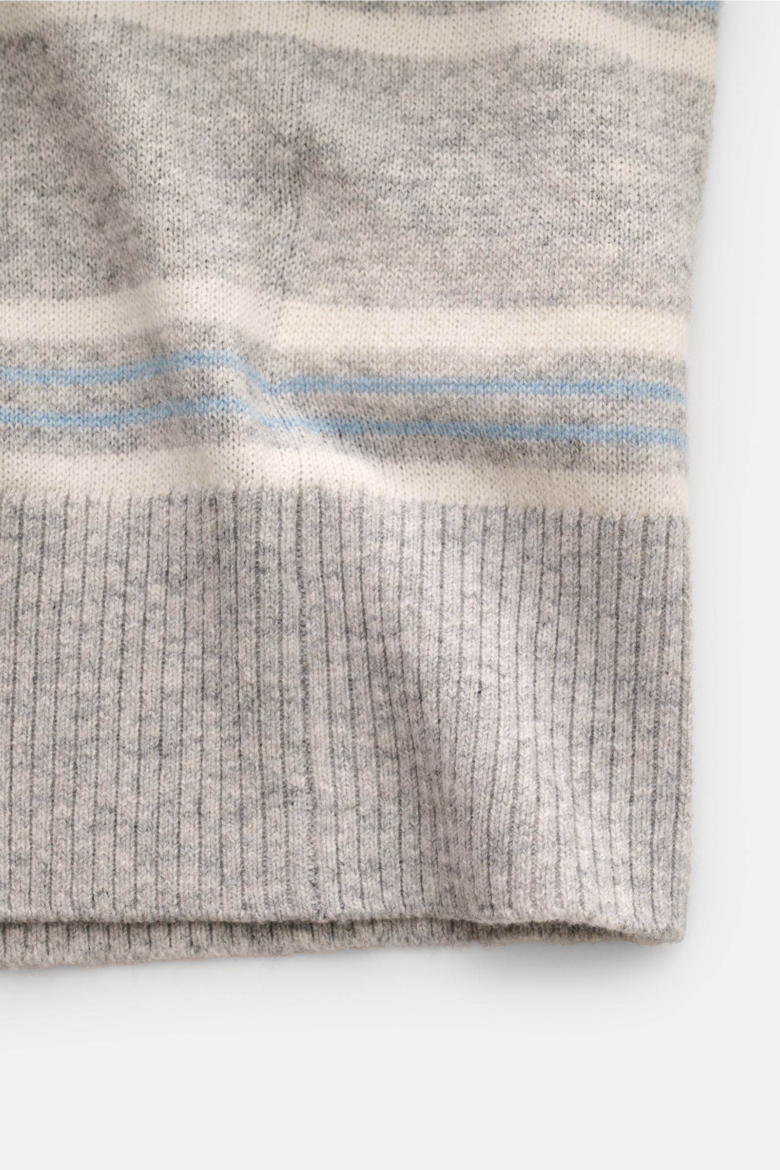 Nahaufnahme des FTC Kurzarm-Strickpolo grau/hellblau/weiß gestreift, Detail des weichen Stricksaums mit flexiblem Rippbündchen aus Baumwolle, SeaCell und Cashmere.