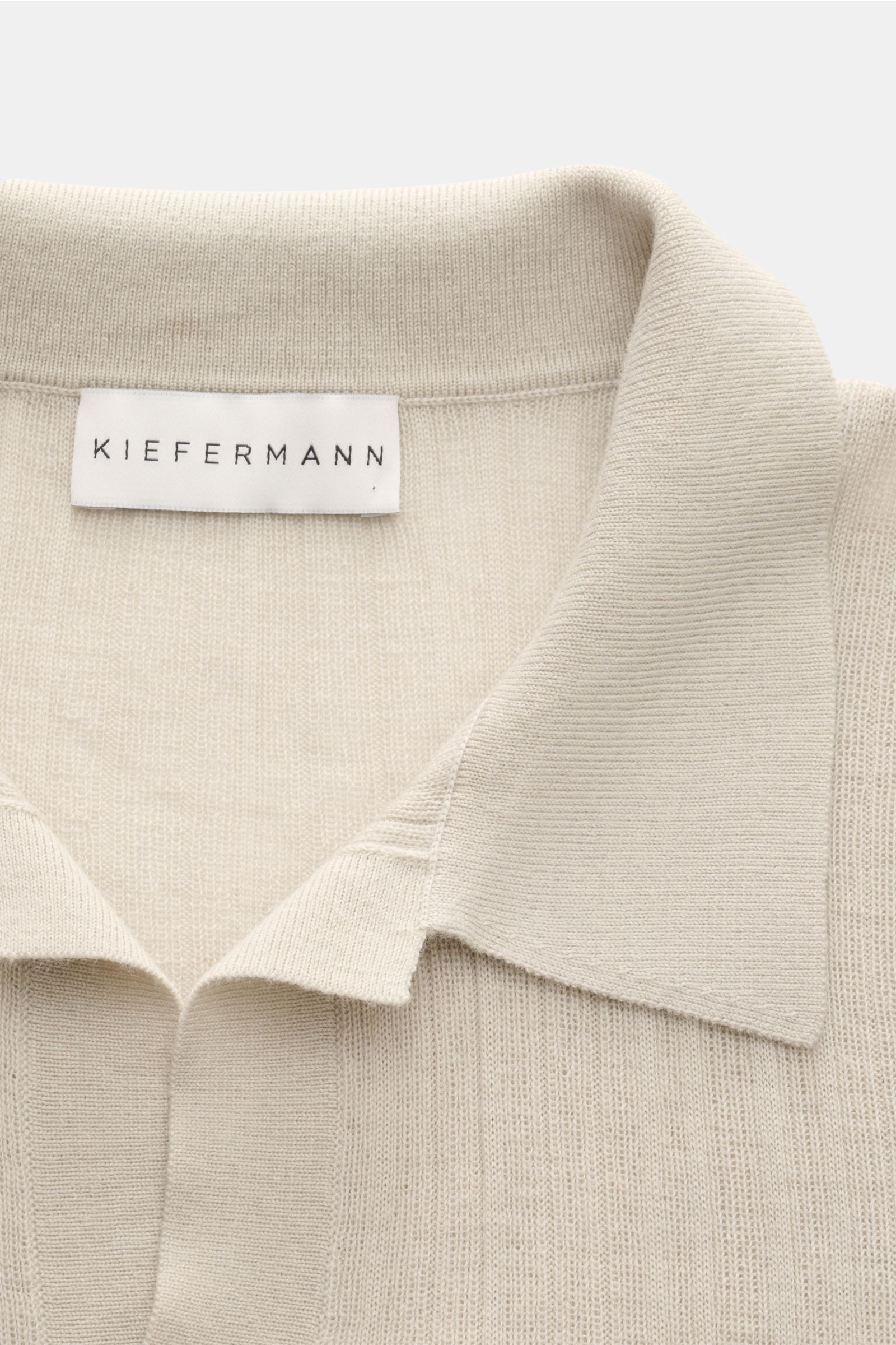 Nahaufnahme des Kiefermann Merino Kurzarm-Strickpolo 'Bortiso' sand mit offenem, gestricktem Polokragen und feinem Strukturstrick aus reiner Merinowolle.