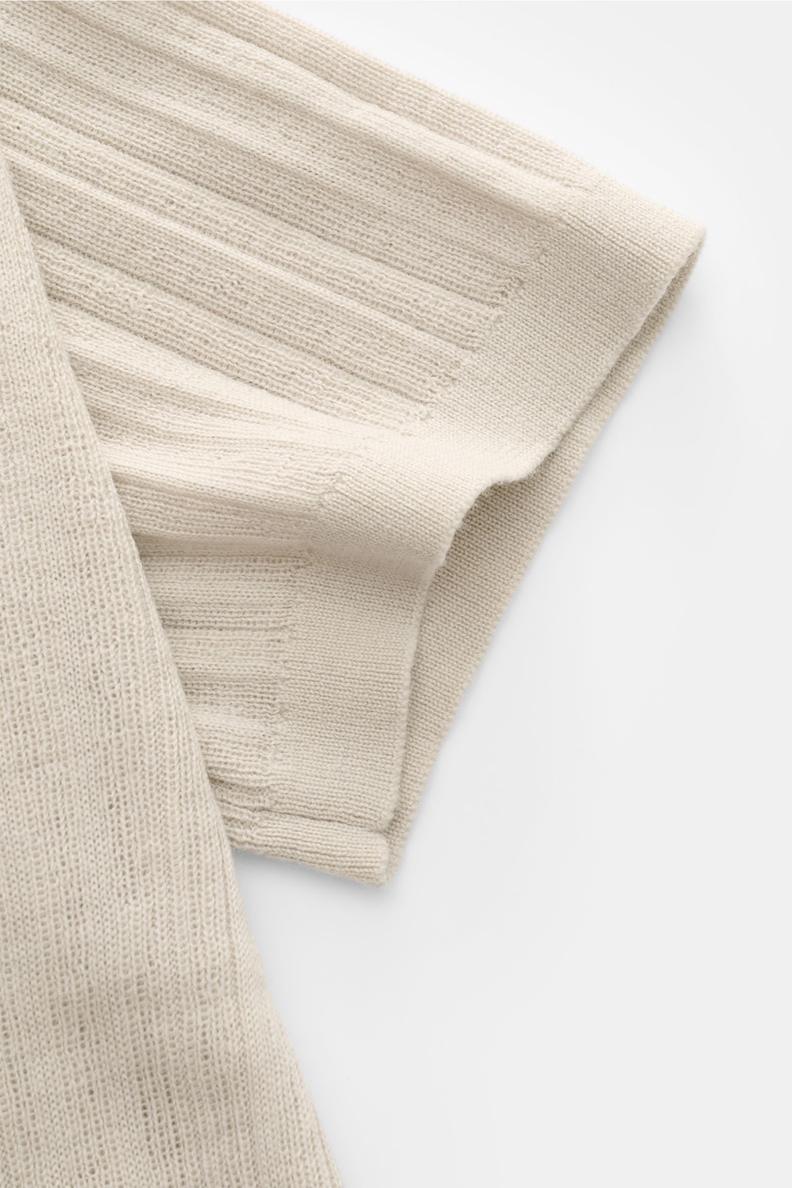 Nahaufnahme des Kiefermann Merino Kurzarm-Strickpolo 'Bortiso' sand, seitlich fotografiert, zeigt feines Strukturstrick und schmale Rippbündchen.