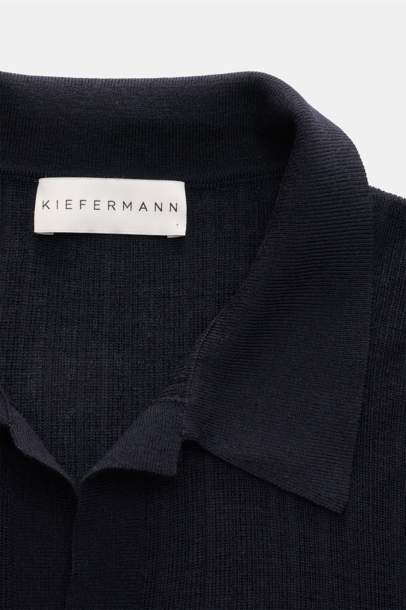 Nahaufnahme von Kragen und Label des Kiefermann Merino Kurzarm-Strickpolo 'Bortiso' navy in feinem Strukturstrick aus reiner Merinowolle.