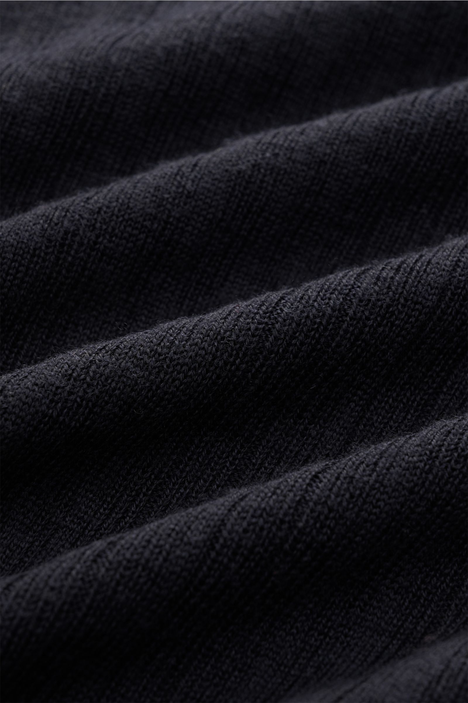 Nahaufnahme des feinen Strukturstricks und luftigen Musters des Kiefermann Merino Kurzarm-Strickpolo 'Bortiso' navy aus reiner Merinowolle.