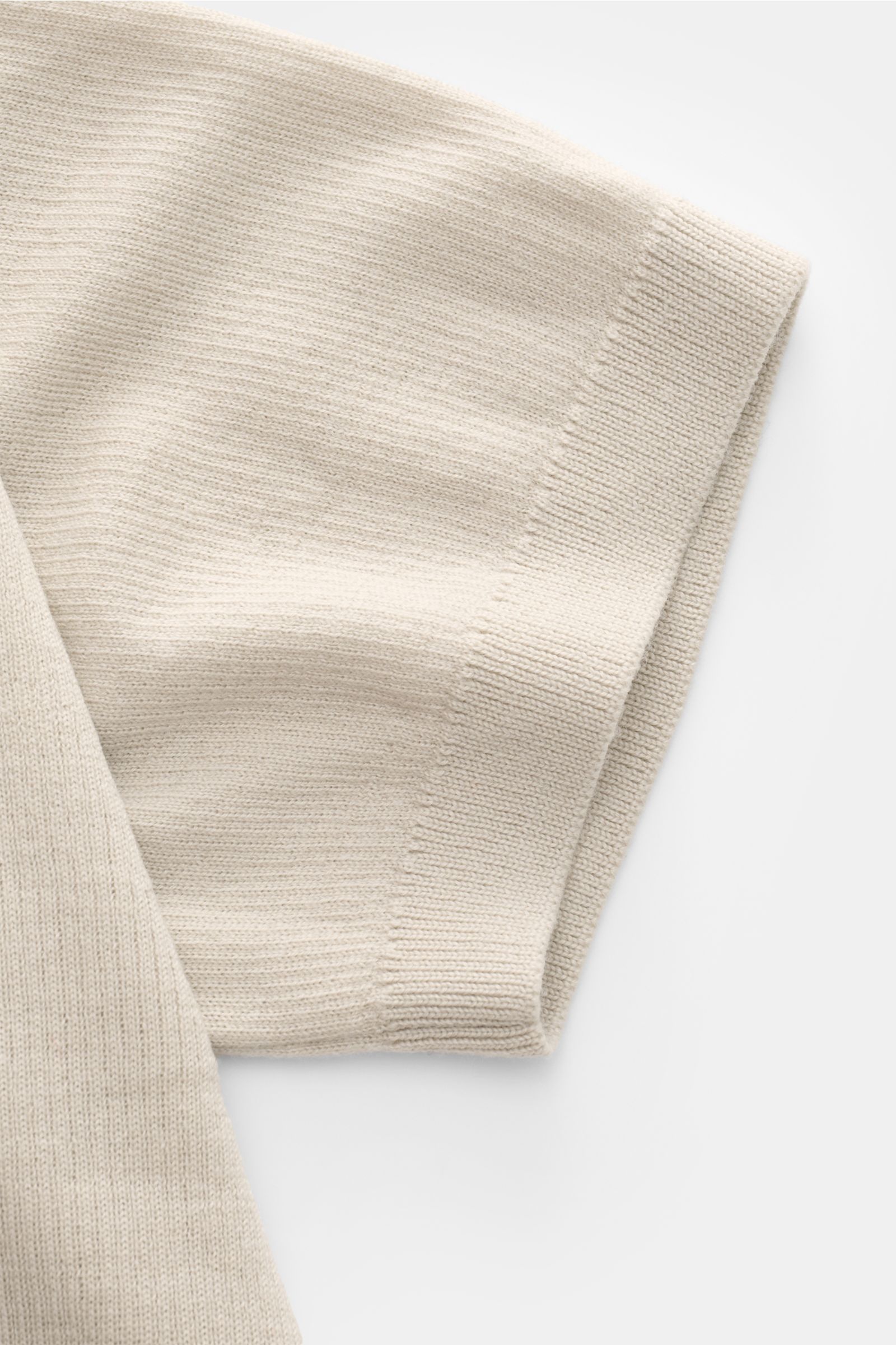 Close-up side view of the sleeve of Kiefermann Merino short sleeve knit polo 'Luras' beige, showcasing fine rib knit and soft merino wool fabric. 

Sporty and timeless: This short sleeve knit polo by KIEFERMANN in high-quality merino wool has a casual 
