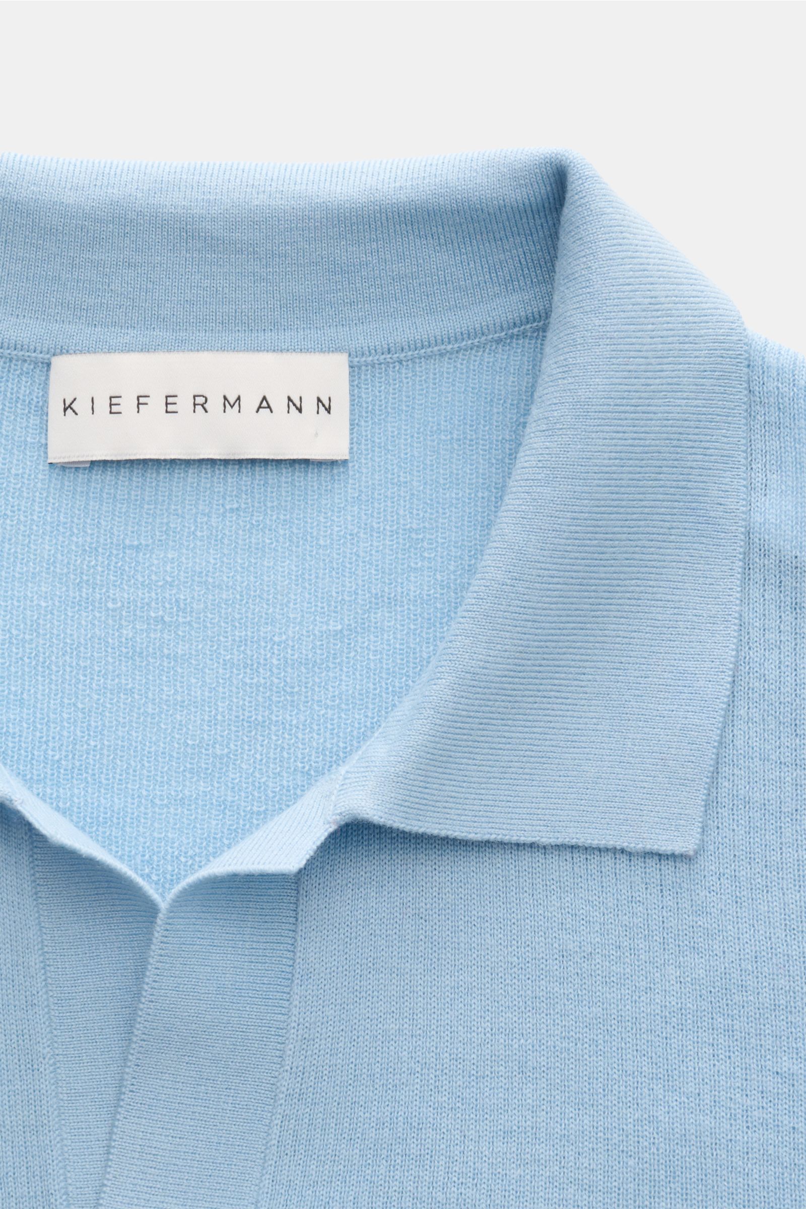 Close-up front view of Kiefermann Merino short sleeve knit polo 'Luras' light blue showing classic collar and fine rib knit texture, pure merino wool.

Description:  
Sporty and timeless: This short sleeve knit polo by KIEFERMANN in high-quality merino