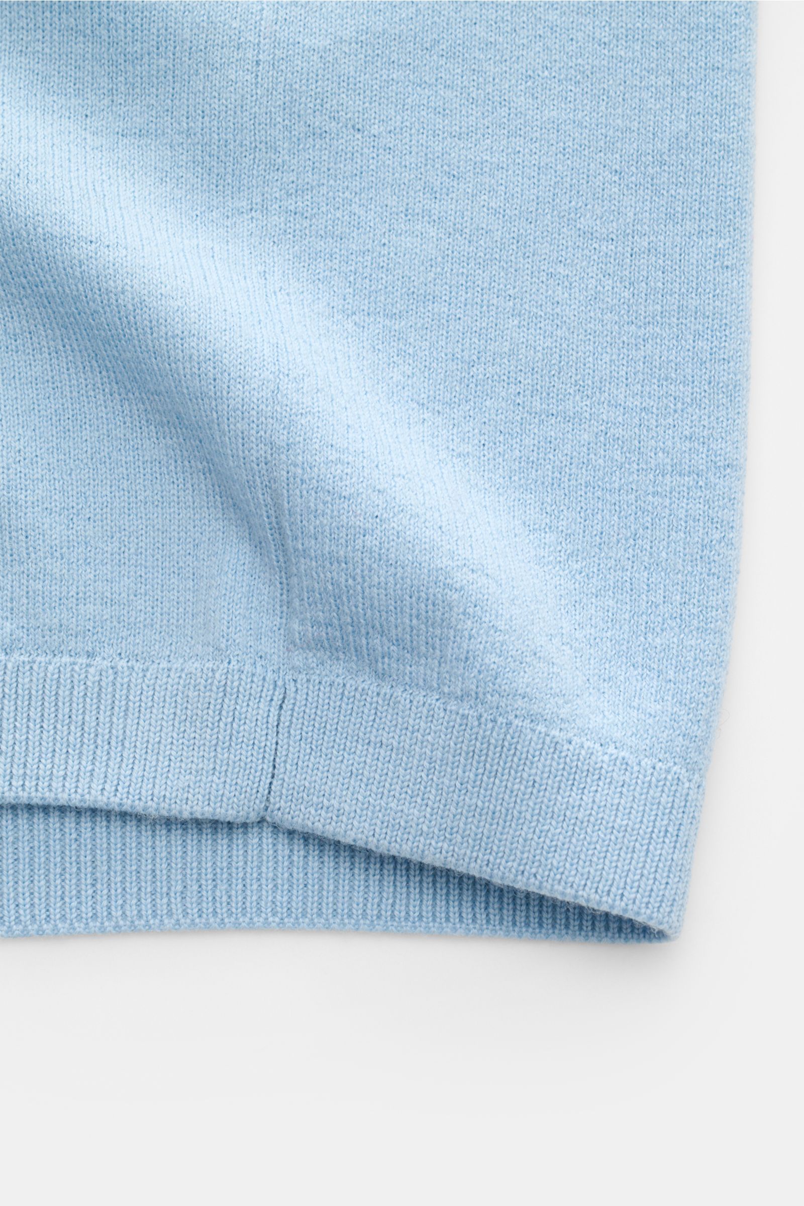 Close-up, bottom hem view of Kiefermann Merino short sleeve knit polo 'Luras' light blue, showing rib knit texture and fine merino wool fabric. Sporty and timeless: This short sleeve knit polo by KIEFERMANN in high-quality merino wool has a casual cut and