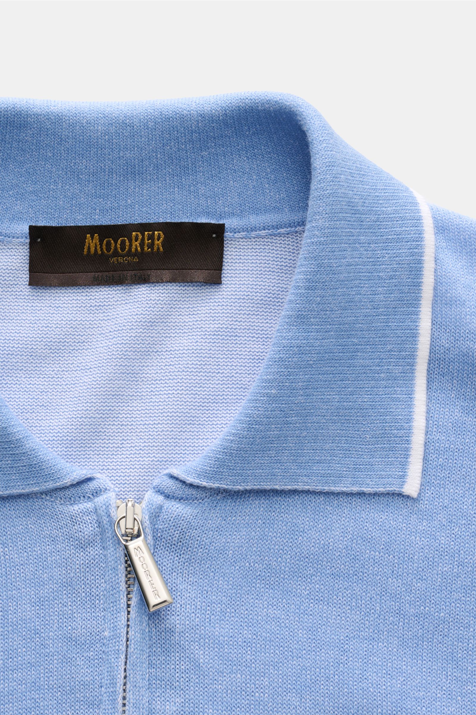 Close-up front view of Moorer Kurzarm-Strickpolo 'Coty' hellblau meliert with a soft cotton knit, slim fit, polo collar with narrow contrast edge, and hidden zipper. Mehr als ein Basic: Für das Strickpolo 'Coty' kombiniert MOORER gekämmte Baumwolle mit Ba