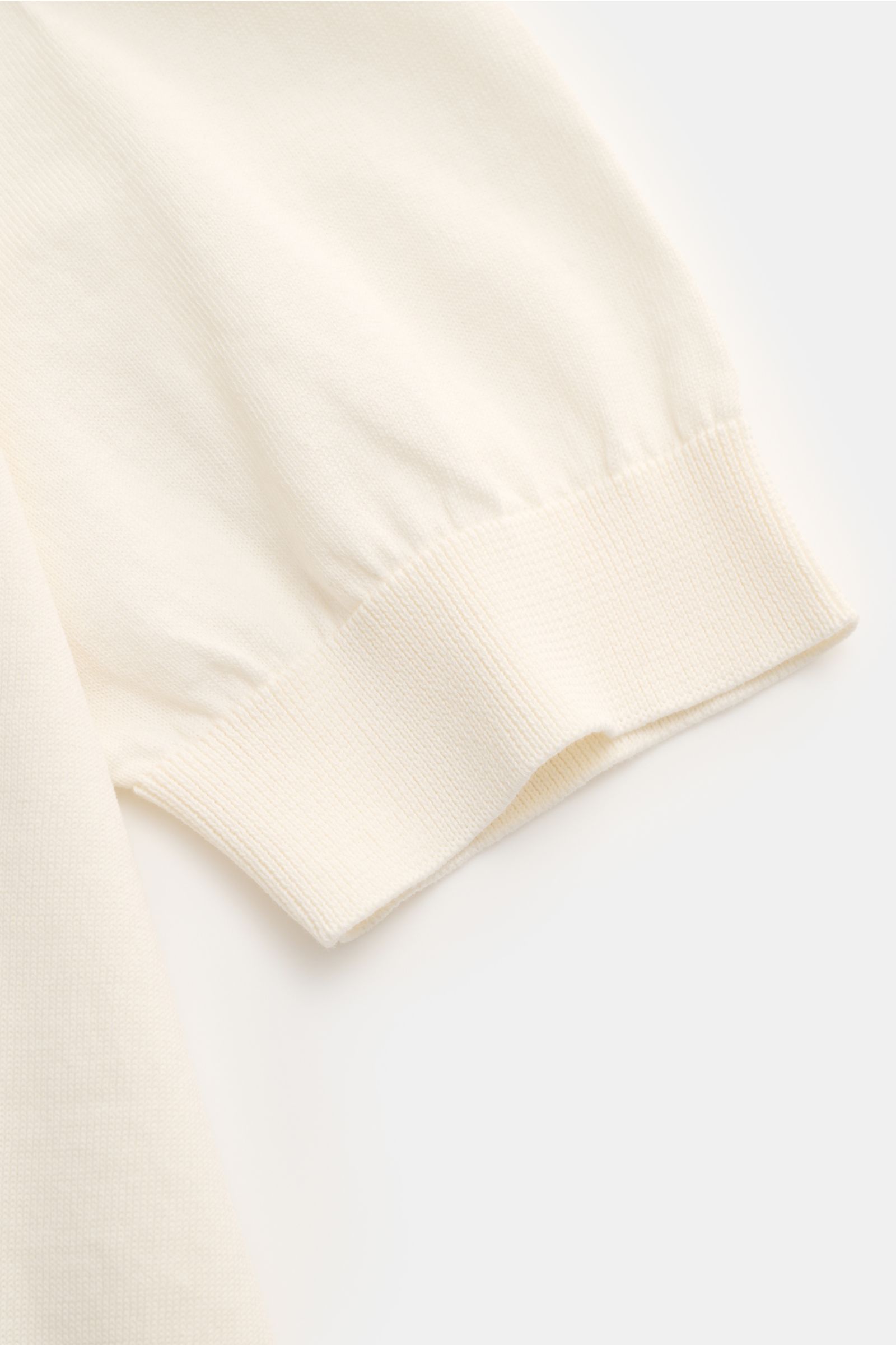 Close-up side view of Filippo de Laurentiis Short sleeve knit polo cream showing fine cotton knit and ribbed cuff detail. Summery elegance at its most relaxed: This short sleeve knit polo by FILIPPO DE LAURENTIIS is made of a fine cotton knit with clean l