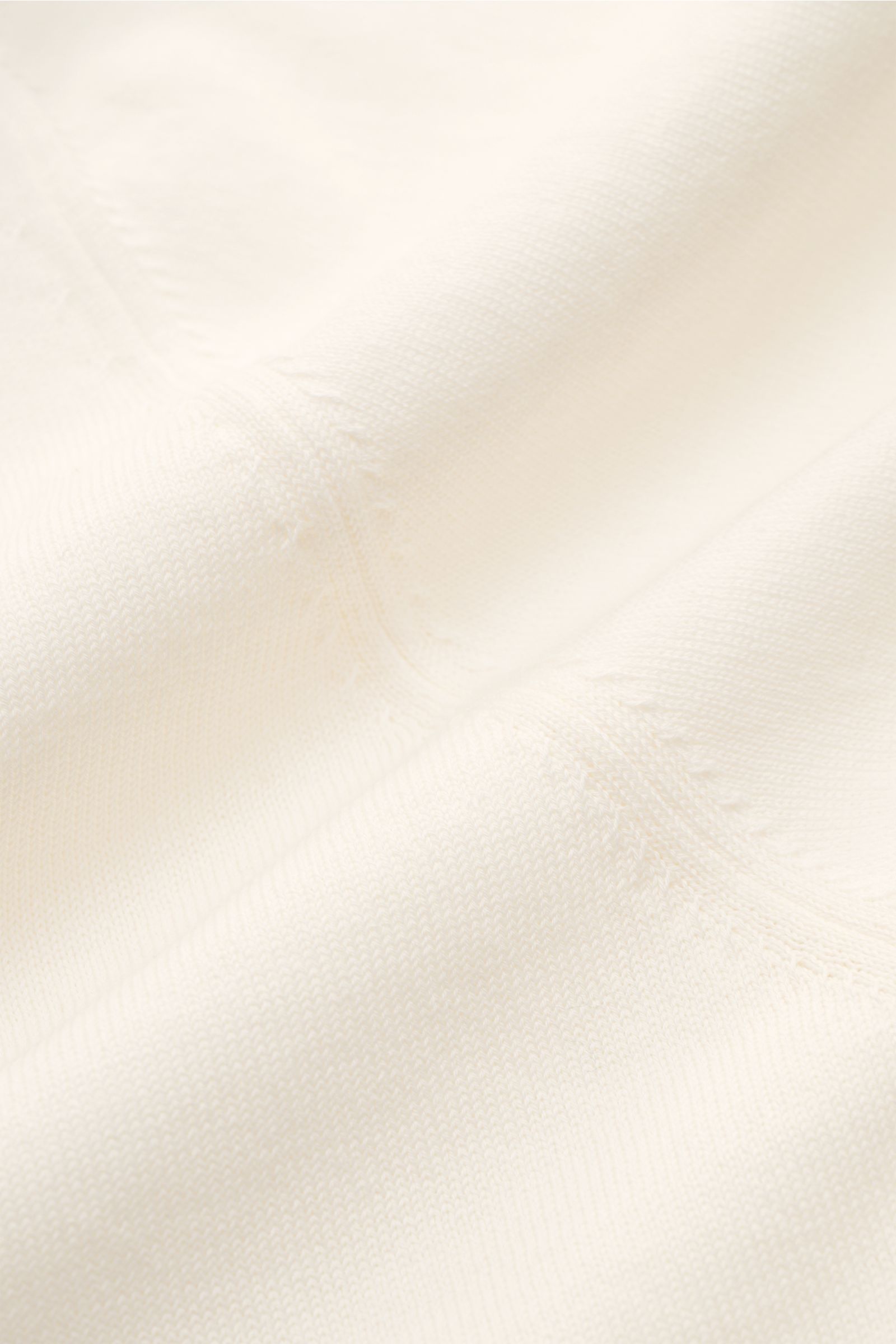 Close-up fabric texture of the Filippo de Laurentiis Short sleeve knit polo cream, photographed from above, showing fine knit cotton. Summery elegance at its most relaxed: This short sleeve knit polo by FILIPPO DE LAURENTIIS is made of a fine cotton knit 