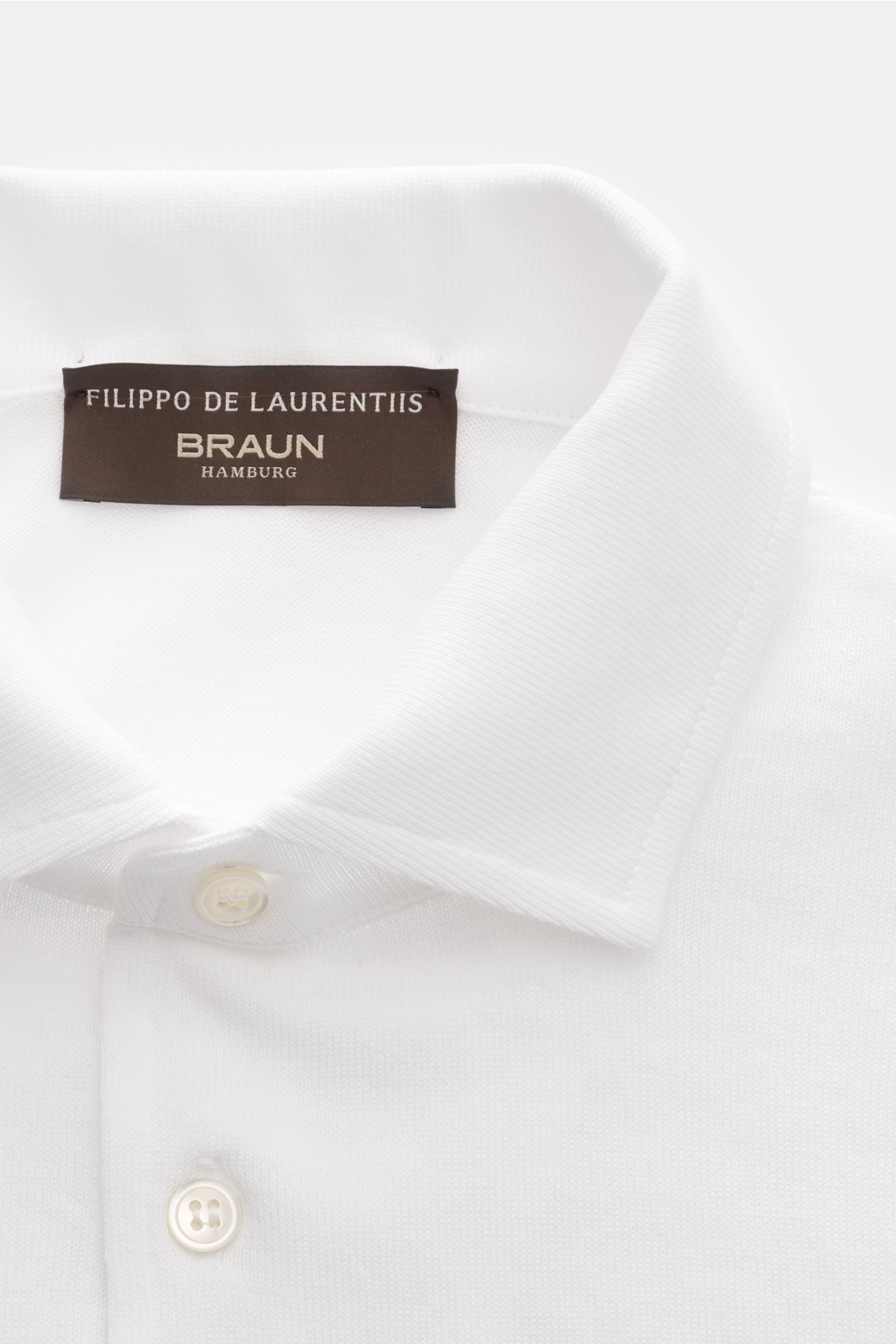 Close-up front view of Filippo de Laurentiis Kurzarm-Strickpolo weiß featuring a knitted polo collar, three-button placket, and fine ribbed cuffs.

Summer feeling von FILIPPO DE LAURENTIIS: Dieses Strickpolo aus leichtem Baumwoll-Strick wird zum smarte