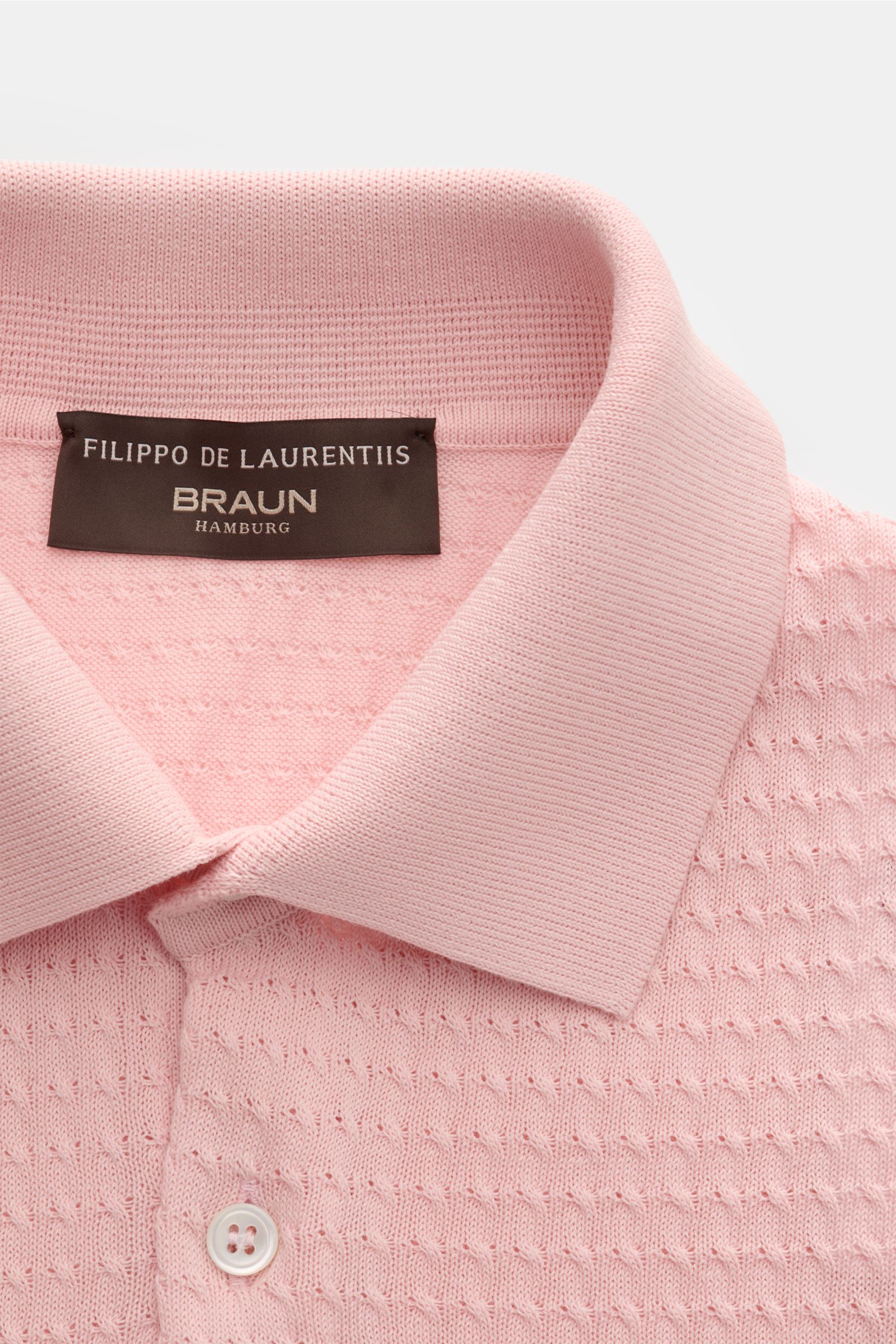 Filippo de Laurentiis Kurzarm-Strickpolo rosé shown from a close-up top front perspective, featuring a knitted polo collar, three-button placket, and fine textured cotton fabric. Darf es etwas neues sein? FILIPPO DE LAURENTIIS präsentiert dieses Strick