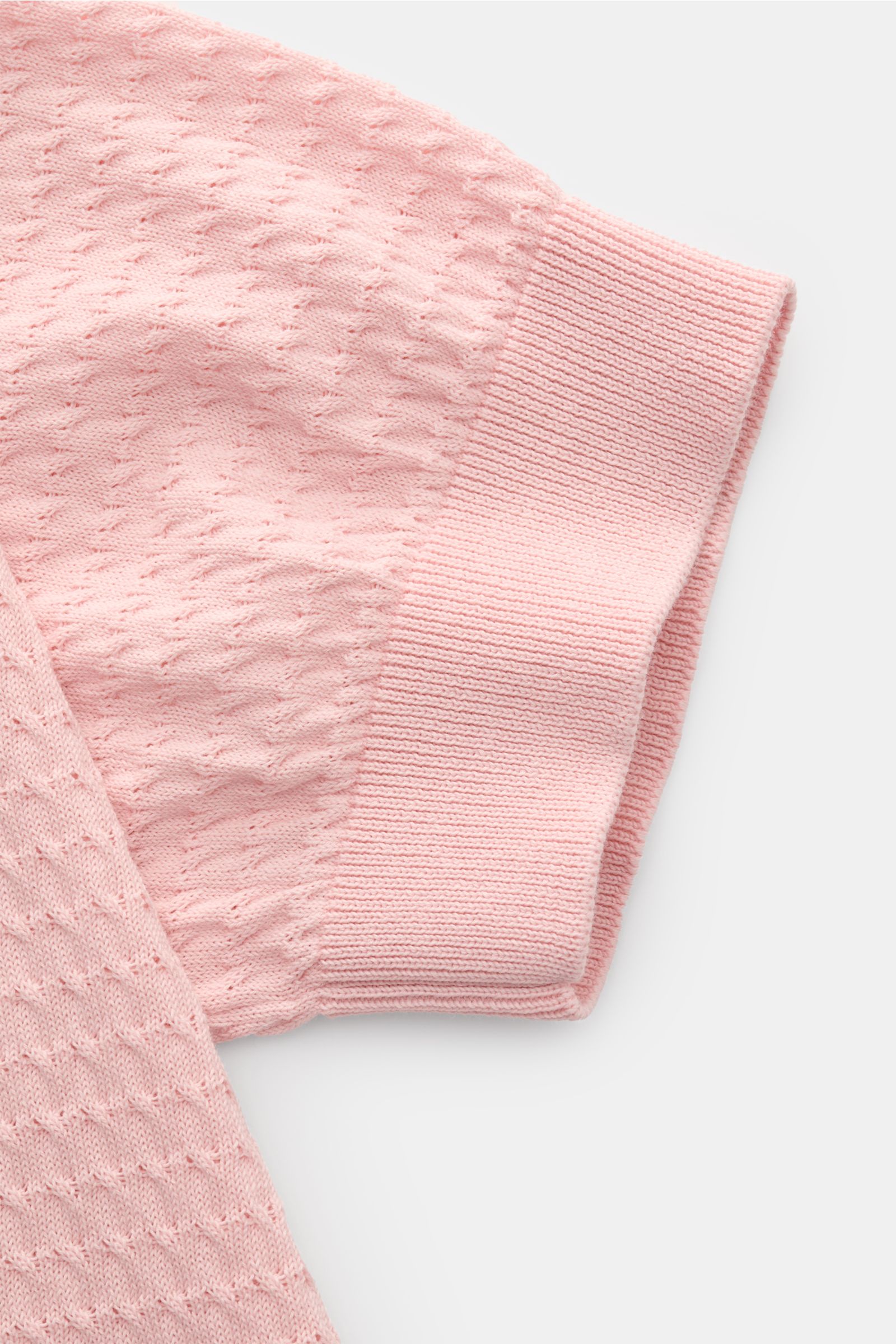 Close-up view of the sleeve of the Filippo de Laurentiis Kurzarm-Strickpolo rosé, showcasing fine structure knit and ribbed cuff. Darf es etwas neues sein? FILIPPO DE LAURENTIIS präsentiert dieses Strickpolo aus luftiger Baumwolle mit edlem, feinen Str