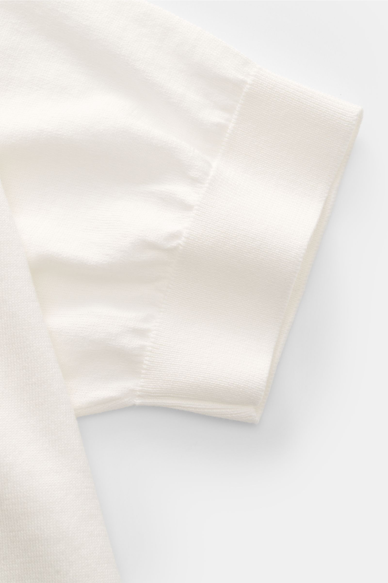 Close-up side view of the Filippo de Laurentiis Kurzarm-Strickpolo offwhite sleeve, showing soft pure cotton fabric, fine knit texture, slim fit, tailored polo collar, smooth three-button placket, and fine ribbed cuffs. Ein perfektes Sommer-Basic: Das 