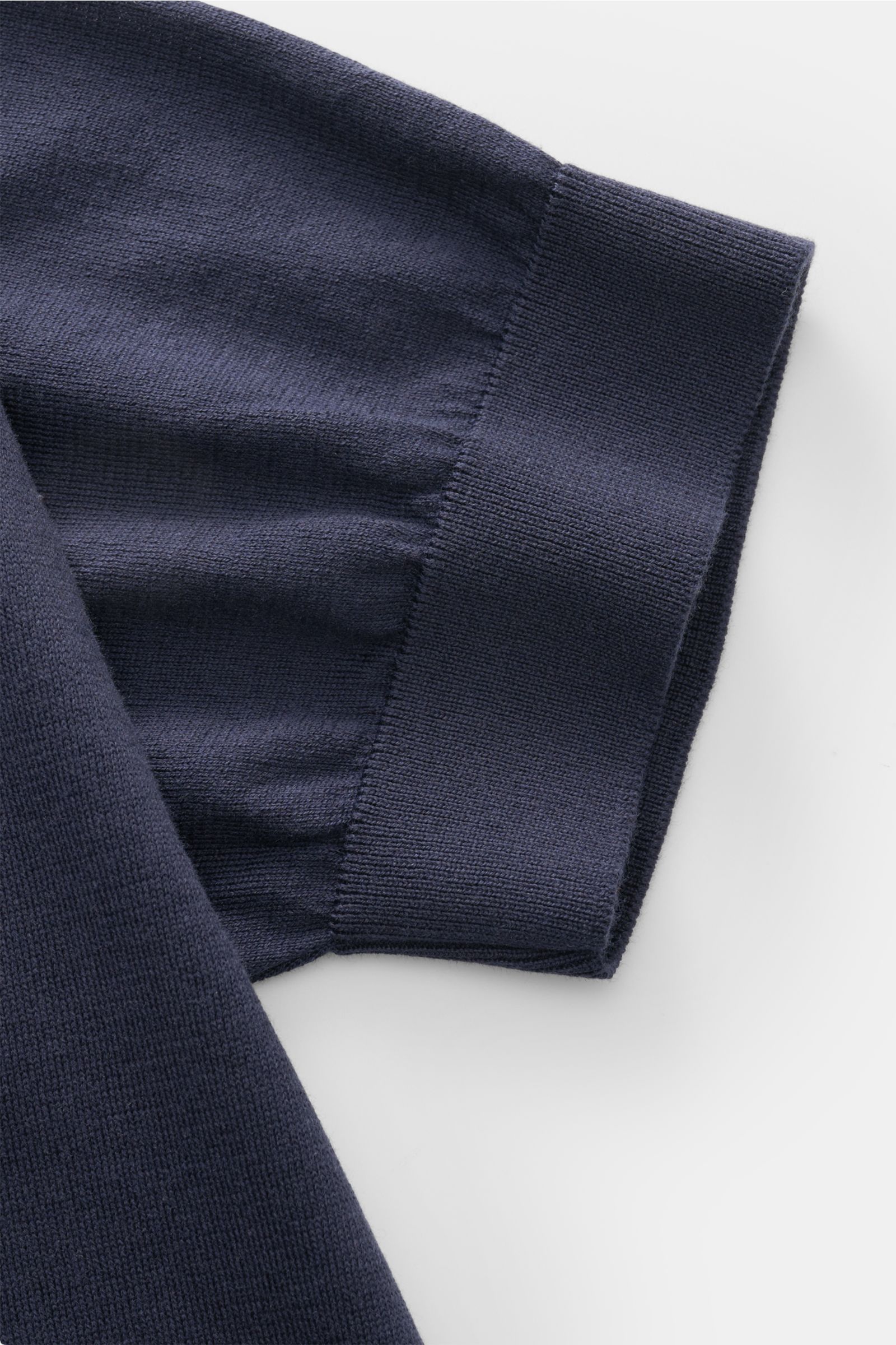 Close-up front view of the sleeve cuff of the Filippo de Laurentiis Kurzarm-Strickpolo navy, made of pure cotton with a soft touch, fine knit, slim fit, tailored polo collar, smooth three-button placket, and fine ribbed cuffs.