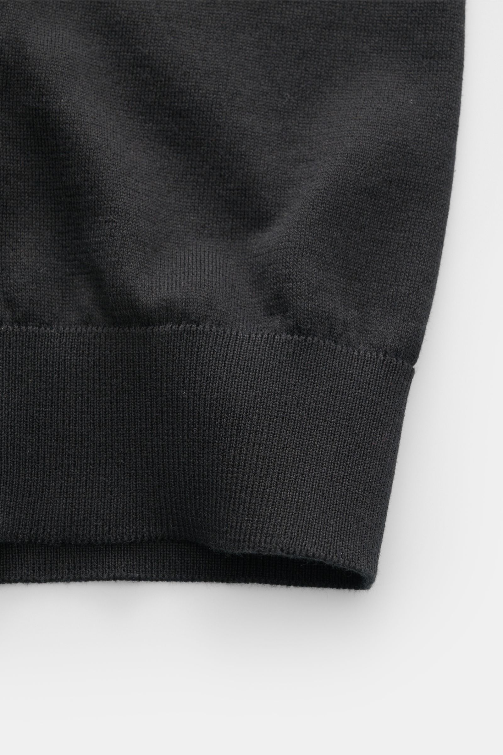 Close-up of the ribbed cuff detail of the Filippo de Laurentiis Kurzarm-Strickpolo schwarz, photographed from a side angle. Ein perfektes Sommer-Basic: Das Kurzarm-Strickpolo von FILIPPO DE LAURENTIIS besticht mit softer Haptik und zeitlosem Design aus re