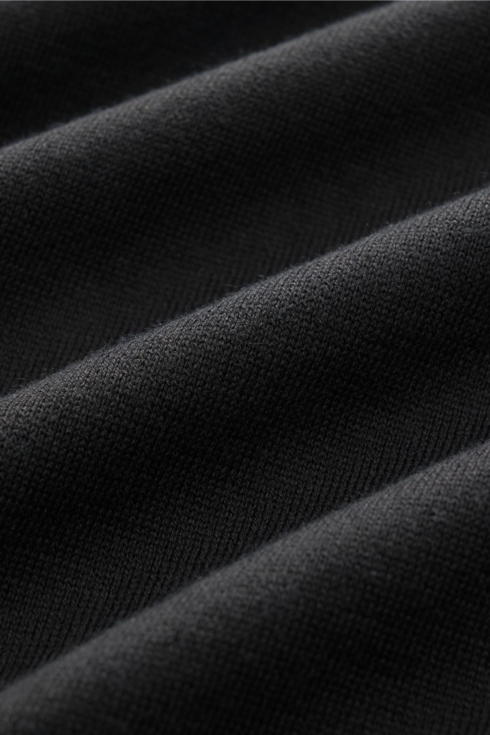 Close-up fabric detail of Filippo de Laurentiis Kurzarm-Strickpolo schwarz showing fine knit texture and soft cotton material from a top-down perspective.