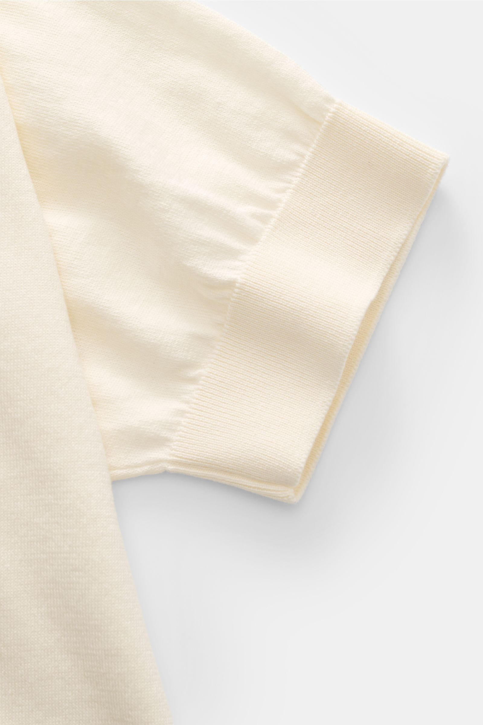 Close-up side view of the sleeve of the Filippo de Laurentiis Kurzarm-Strickpolo creme, a soft, pure cotton short-sleeve knit polo with fine ribbed cuffs. 

Ein perfektes Sommer-Basic: Das Kurzarm-Strickpolo von FILIPPO DE LAURENTIIS besticht mit softe