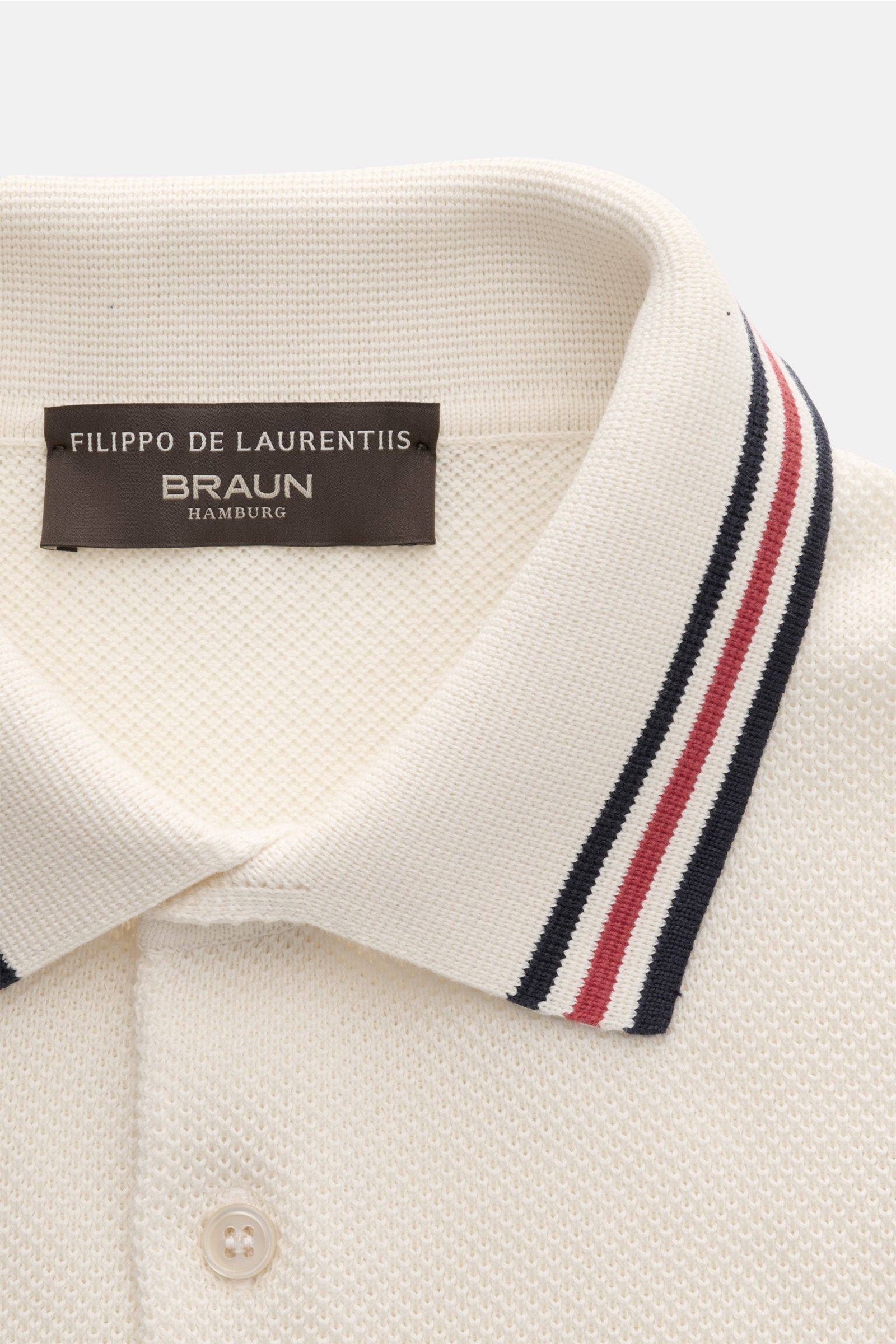 Close-up front view of Filippo de Laurentiis Short sleeve knit polo cream showing fine textured knit, slim fit, polo collar with contrasting navy and red stripes, and three-button placket.

Subtle luxury from FILIPPO DE LAURENTIIS – this knit polo in p