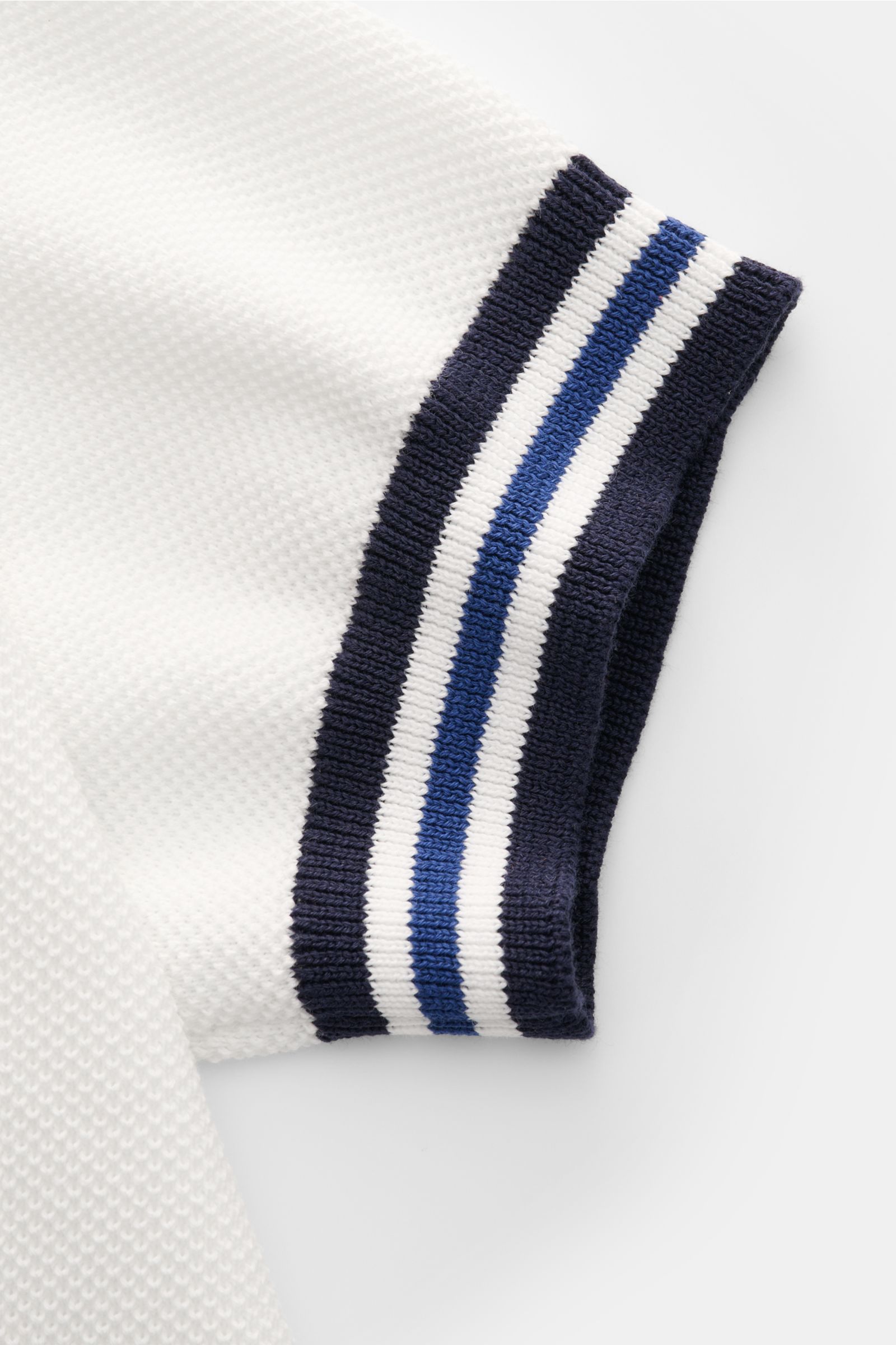 Close-up side view of Filippo de Laurentiis Short sleeve knit polo shirt white showing fine textured knit and contrasting navy and blue ribbed bands on sleeve cuff.

Subtle luxury from FILIPPO DE LAURENTIIS – this knit polo in pure cotton in a fine tex