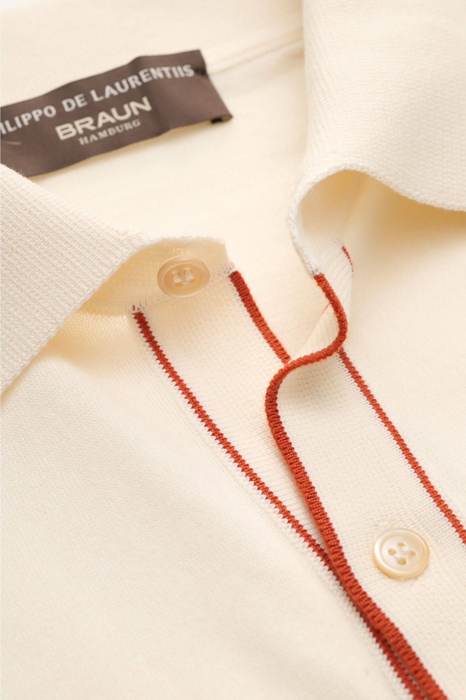 Nahaufnahme aus schräger Perspektive des cremefarbenen Filippo de Laurentiis Kurzarm-Strickhemds mit Polokragen, feinen Kontraststreifen, weichem Griff und Rippbündchen aus reiner Baumwolle.