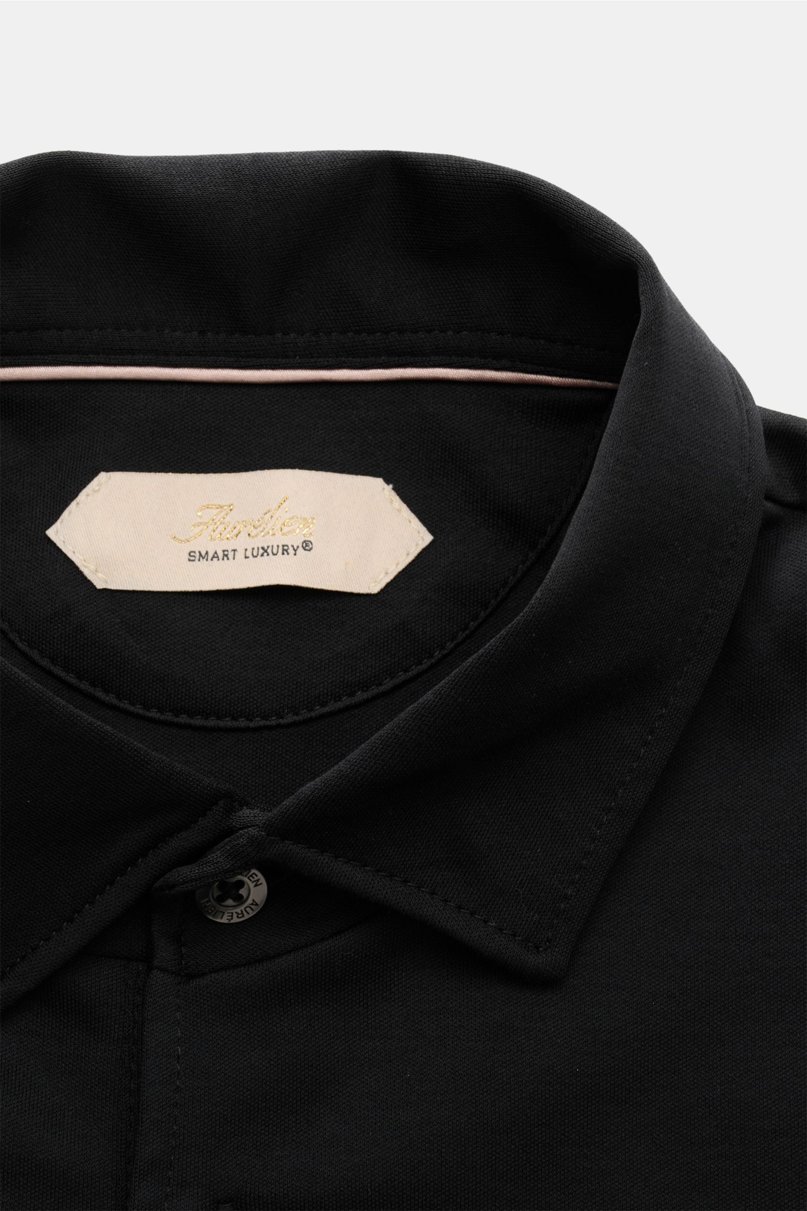 Aurélien Jersey Poloshirt schwarz, Nahaufnahme von oben auf Polokragen mit Drei-Knopf-Leiste, aus weichem ägyptischem Baumwolljersey.