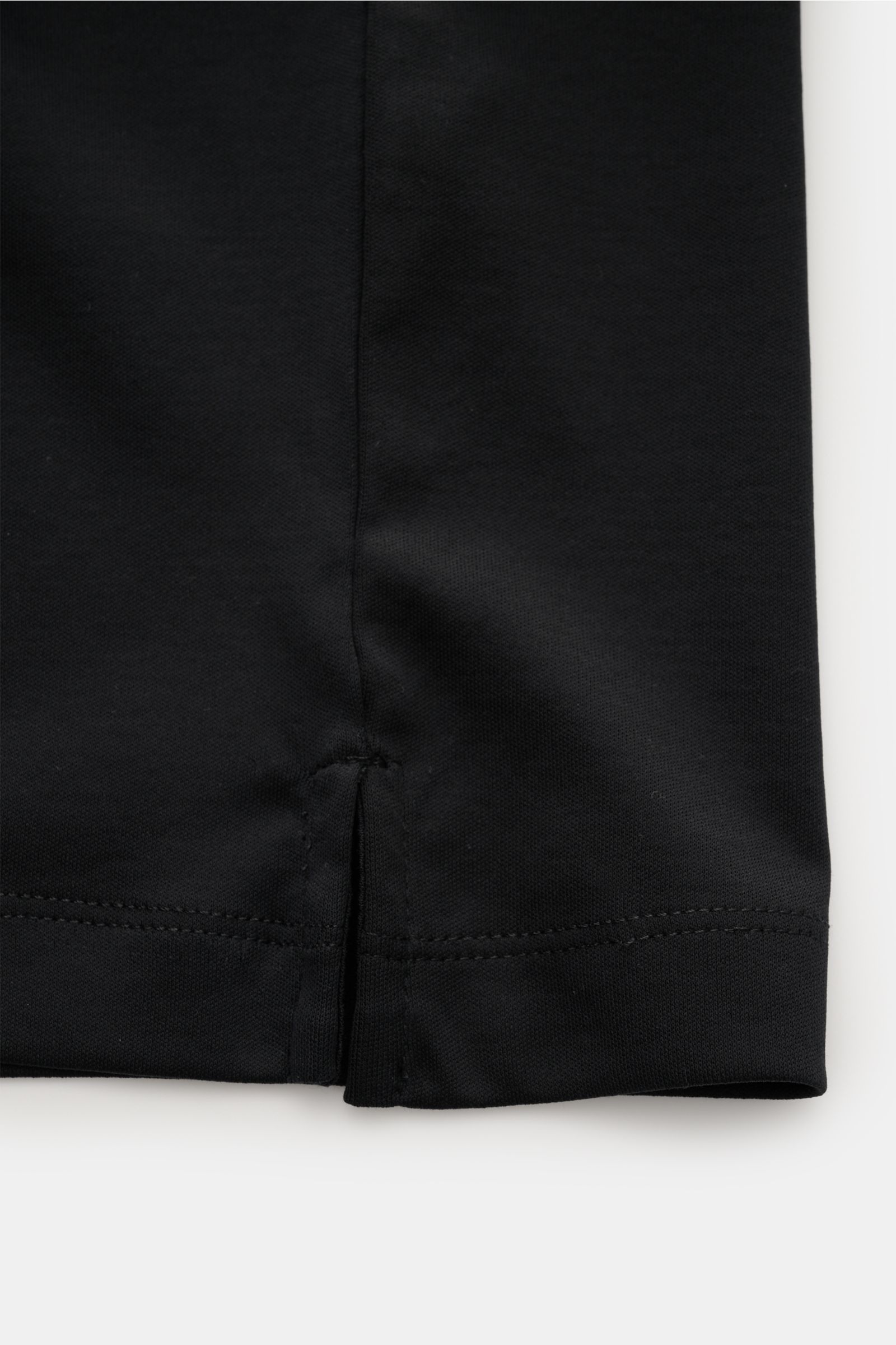 Aurélien Jersey Poloshirt schwarz, Detailaufnahme des Saums mit kurzer Saumschlitze aus ägyptischer Baumwolle, feiner Jersey-Qualität.