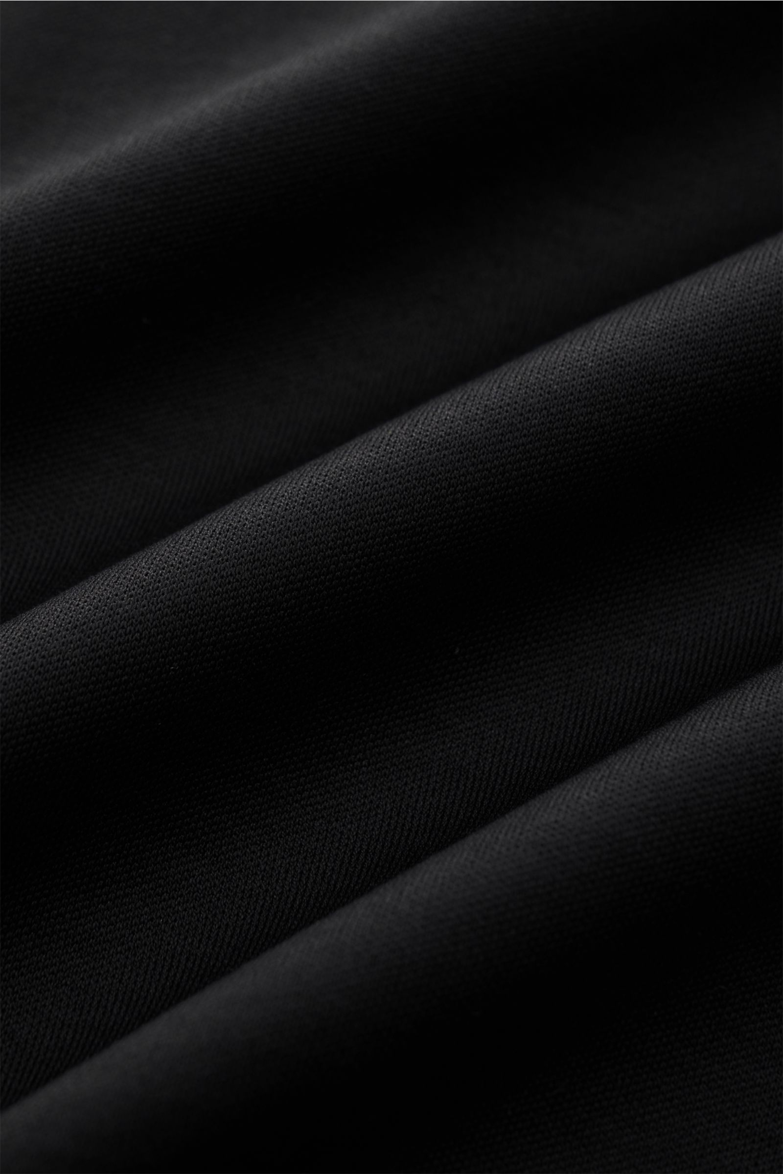 Aurélien Jersey Poloshirt schwarz, Detailaufnahme der feinen ägyptischen Baumwolle in Jersey-Qualität, weicher Griff sichtbar.