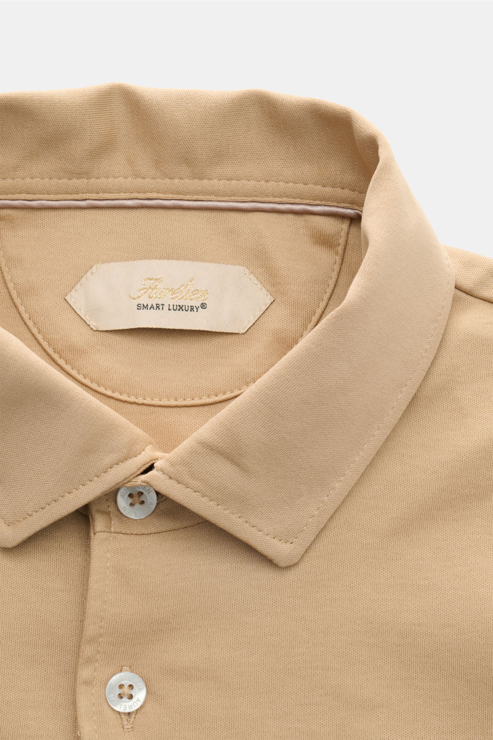 Aurélien Jersey Poloshirt beige in Nahaufnahme von oben, Slim Fit aus ägyptischer Baumwolle mit Polokragen, Drei-Knopf-Leiste.