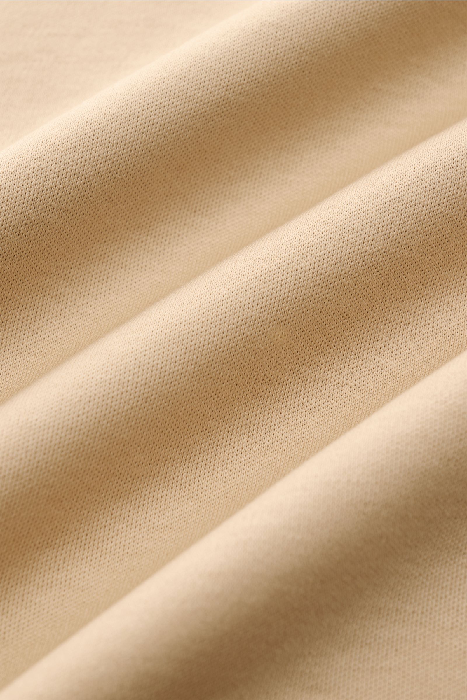 Nahaufnahme des beigen Aurélien Jersey Poloshirts aus ägyptischer Baumwolle mit feiner Jersey-Qualität, weichem Griff und sichtbarer Struktur.