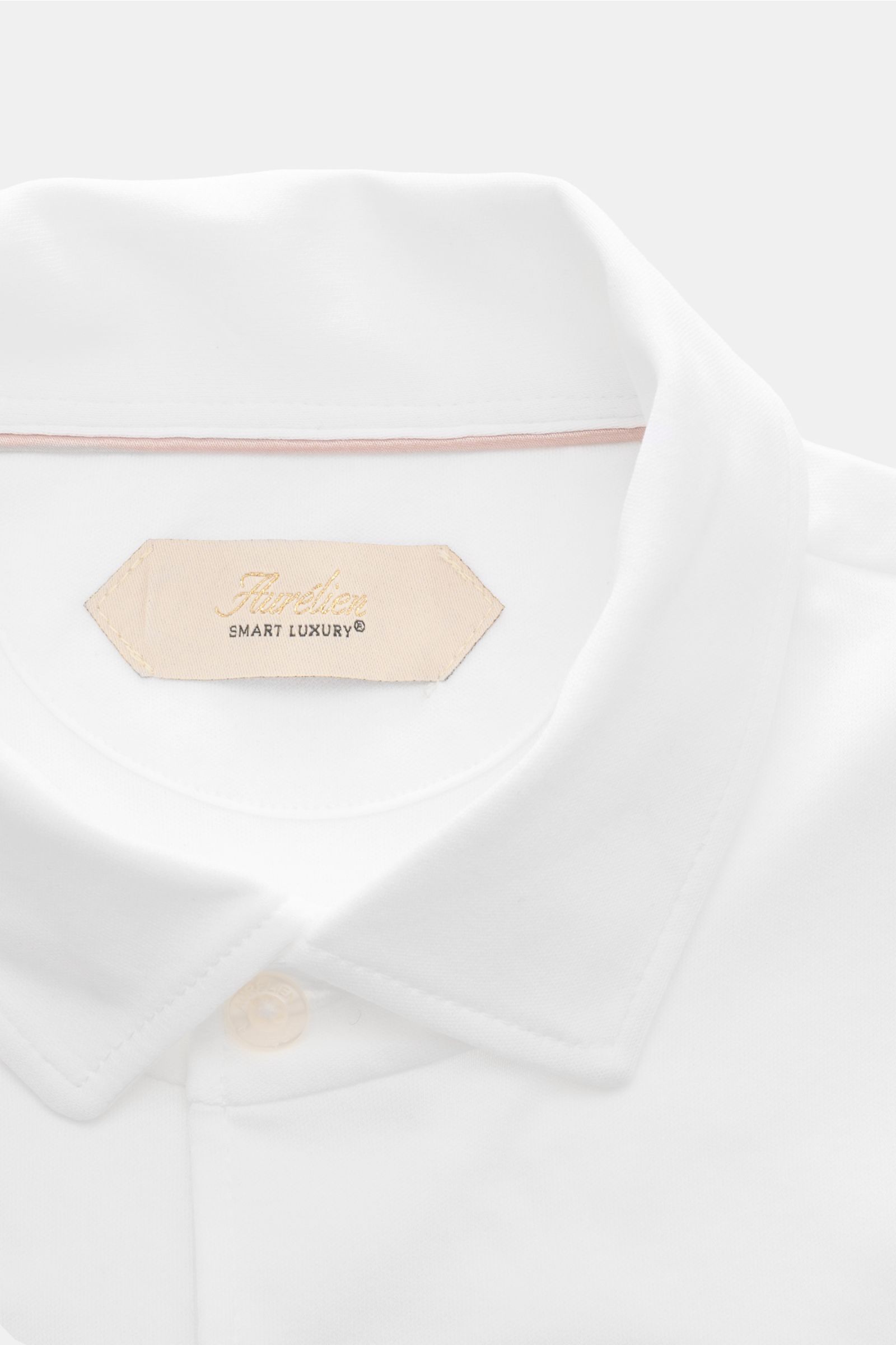 Aurélien Jersey Poloshirt weiß, Detailaufnahme von oben, Polokragen, Drei-Knopf-Leiste, edle ägyptische Baumwolle, Slim Fit, dezentes Logo innen.