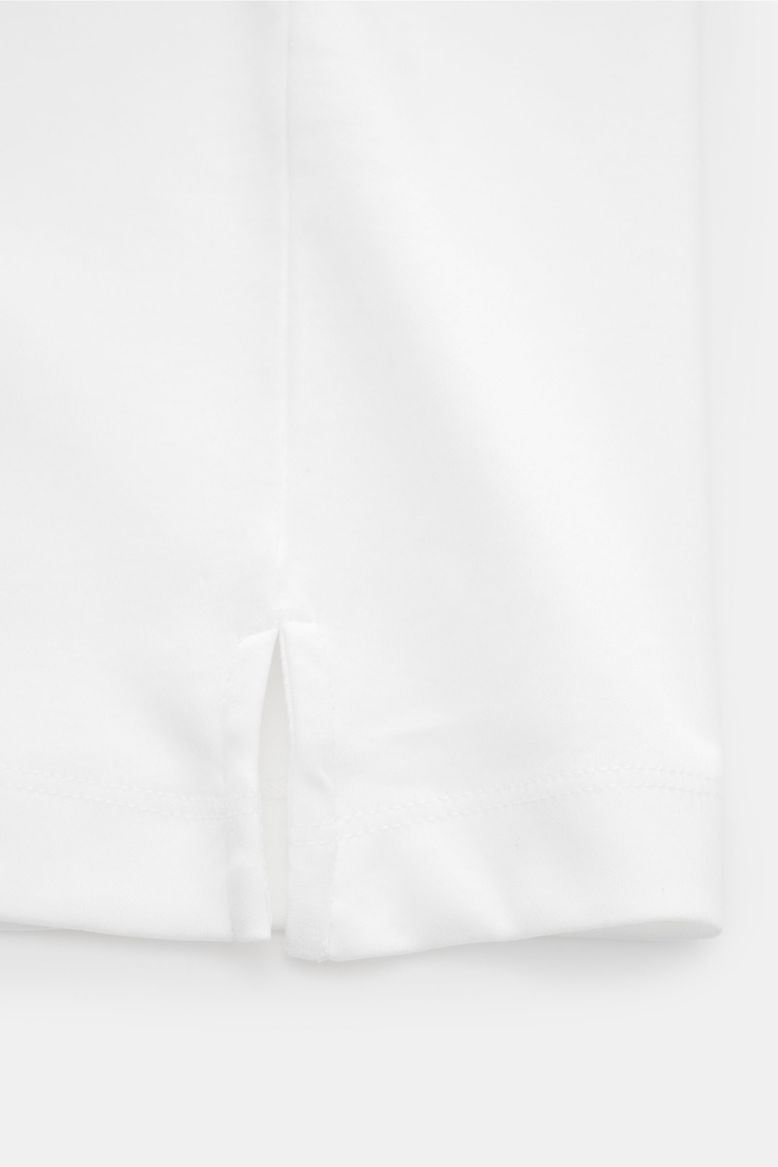 Aurélien Jersey Poloshirt weiß, Detailansicht des Saums mit kurzen Schlitzen, aus ägyptischer Baumwolle, Slim Fit, glatter Griff.
