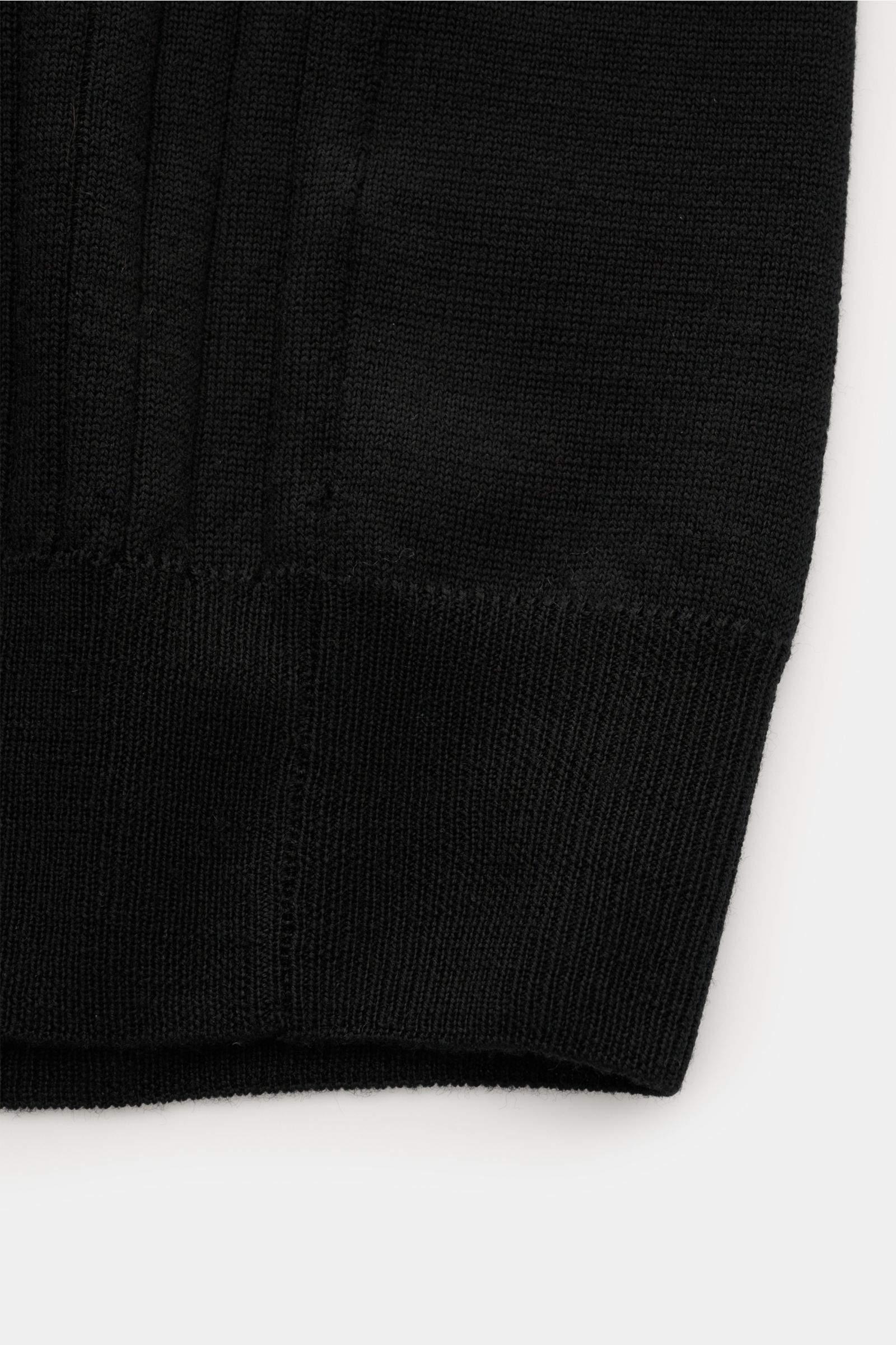 Aurélien Merino Kurzarm-Strickpolo schwarz, Detailaufnahme der Rippbündchen aus weichem Merinowolle-Strick in Slim Fit, von unten fotografiert.