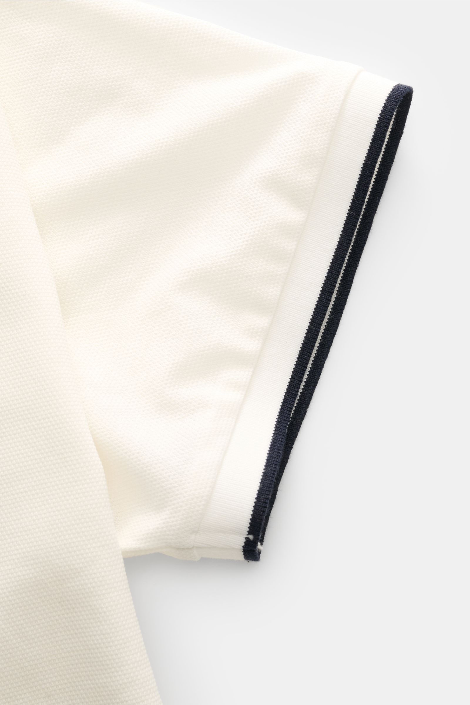 Zeybra Portofino 1962 Poloshirt offwhite, Nahaufnahme Ärmel in Slim Fit aus Baumwoll-Piqué, Kontrastkanten am Bündchen, seitliche Perspektive.