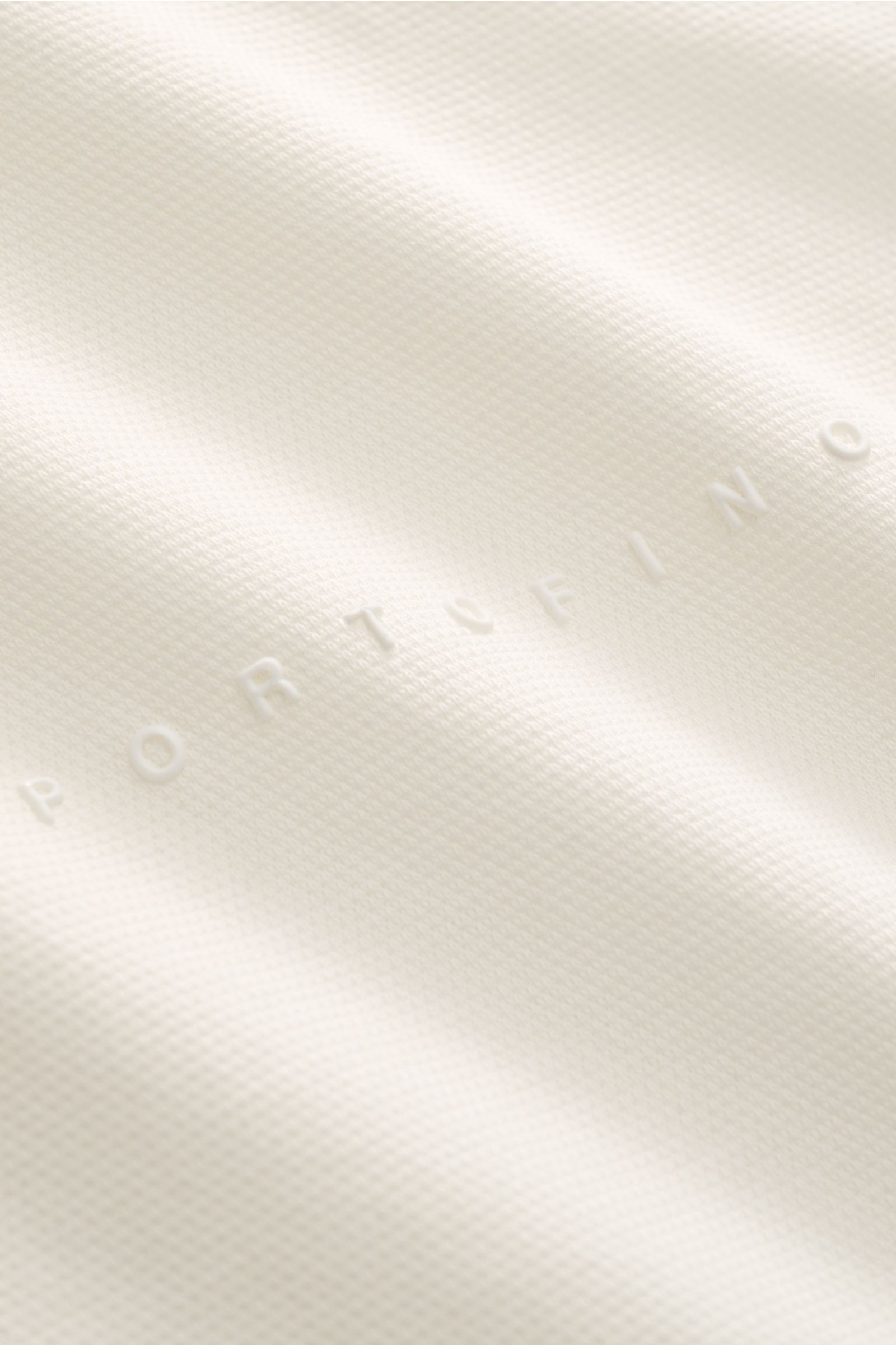 Zeybra Portofino 1962 Poloshirt offwhite in Slim Fit, halbseitige Nahaufnahme von oben, reine Baumwolle mit Piqué-Struktur, Kontrastkanten, zwei Knöpfen, tonales Logo.