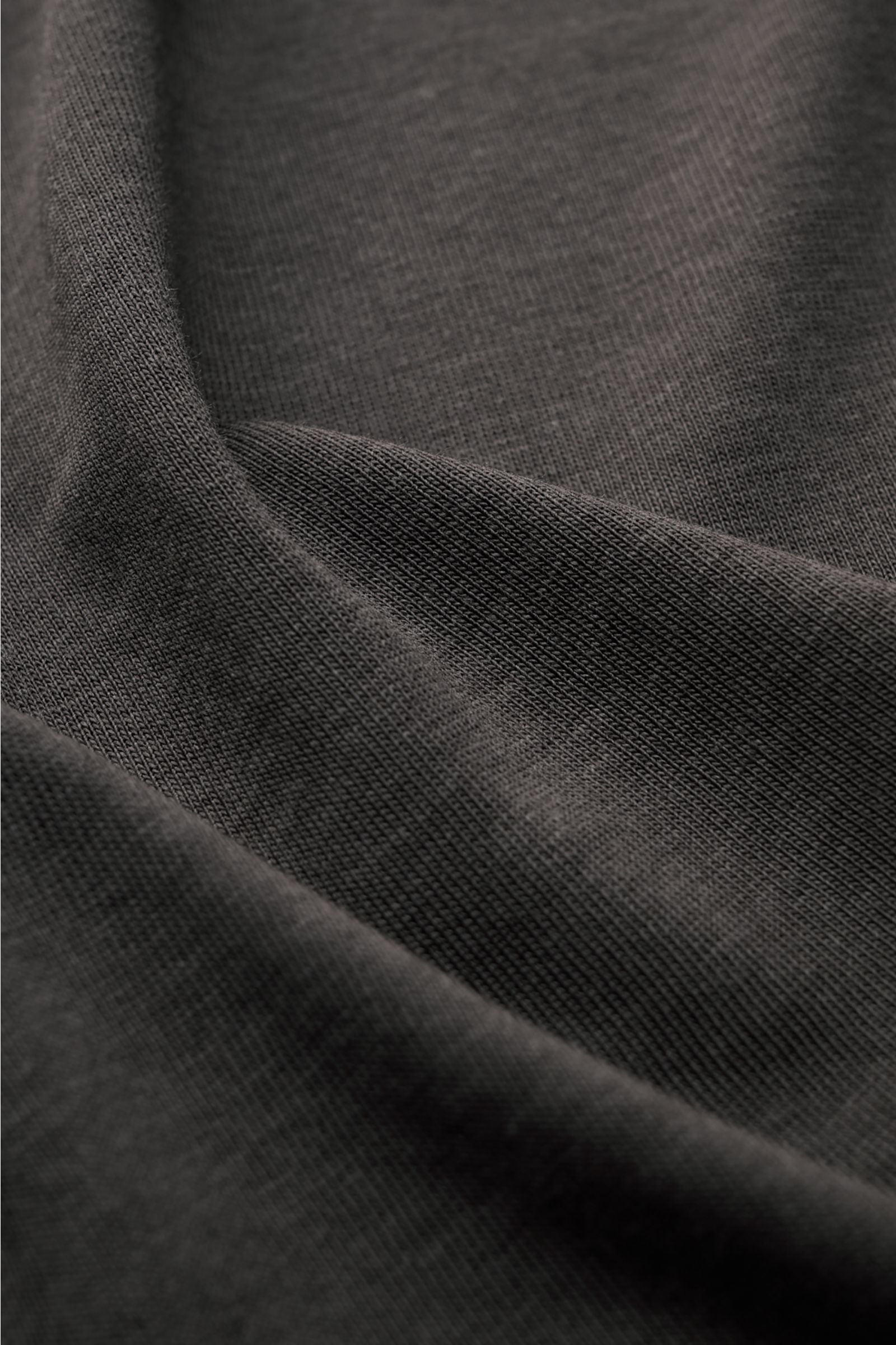 Close-up front view of the fine knit texture of the Altea Kurzarm-Strickpolo 'Pierre' graubraun, a slim fit short-sleeve polo made from a soft Lyocell-cotton mix with an open collar placket and elastic ribbed cuffs. Für ein sommerliches Gefühl: Das luf