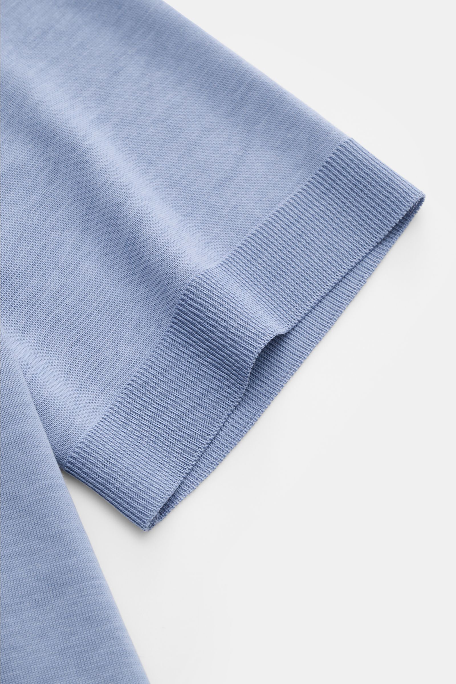 Close-up side view of the sleeve of the Altea Kurzarm-Strickpolo 'Pierre' rauchblau, a slim fit short-sleeve knit polo in soft lyocell-cotton blend with fine knit texture, typical polo collar, open placket, and elastic rib cuffs, perfect for a summery fee