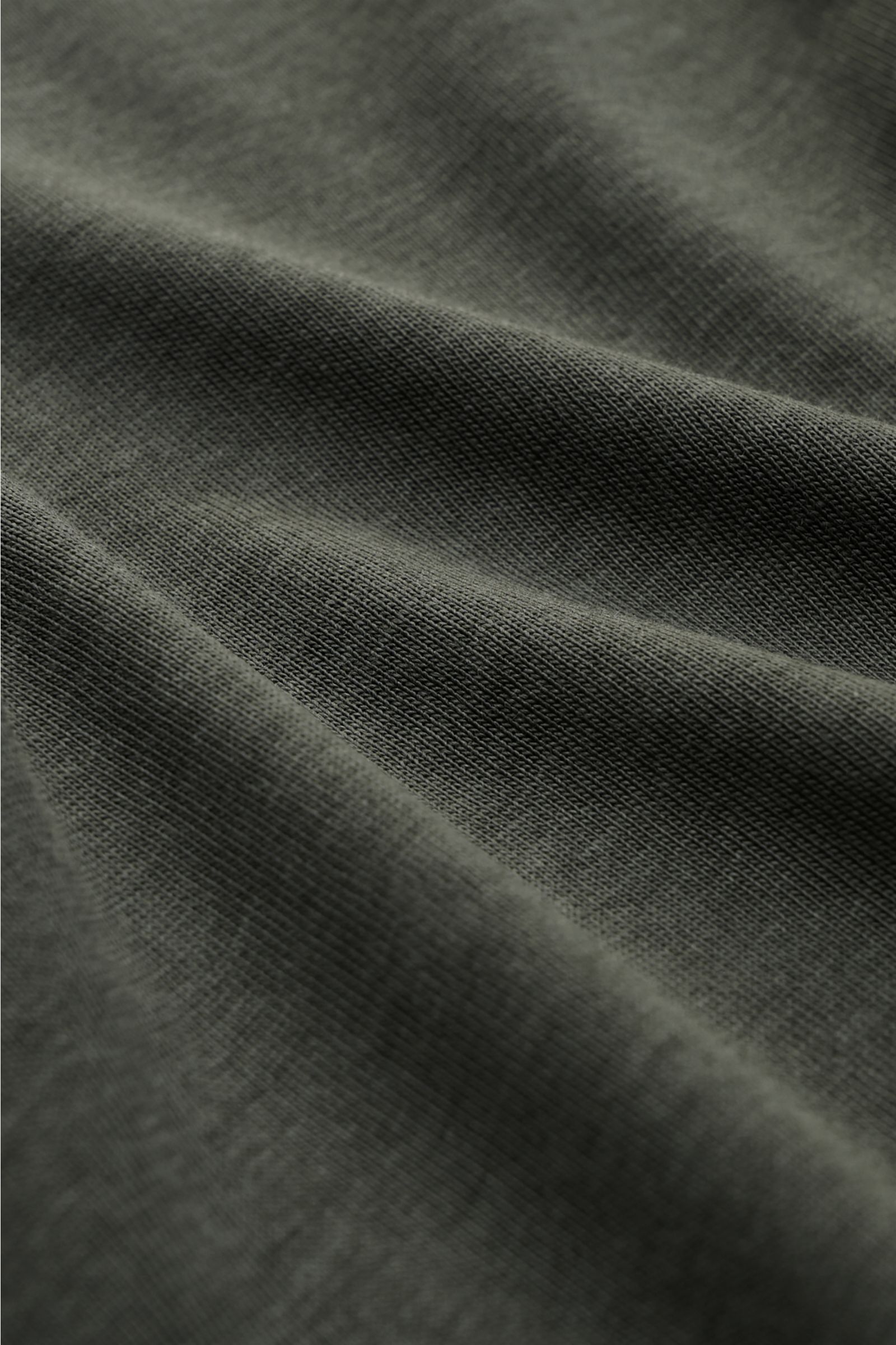 Close-up fabric detail of Altea Kurzarm-Strickpolo 'Pierre' graugrün showing soft, fine knit texture from a top-down perspective, made of lyocell-cotton mix. Für ein sommerliches Gefühl: Das luftige Kurzarm-Strickpolo 'Pierre' von ALTEA aus softem Lyocell