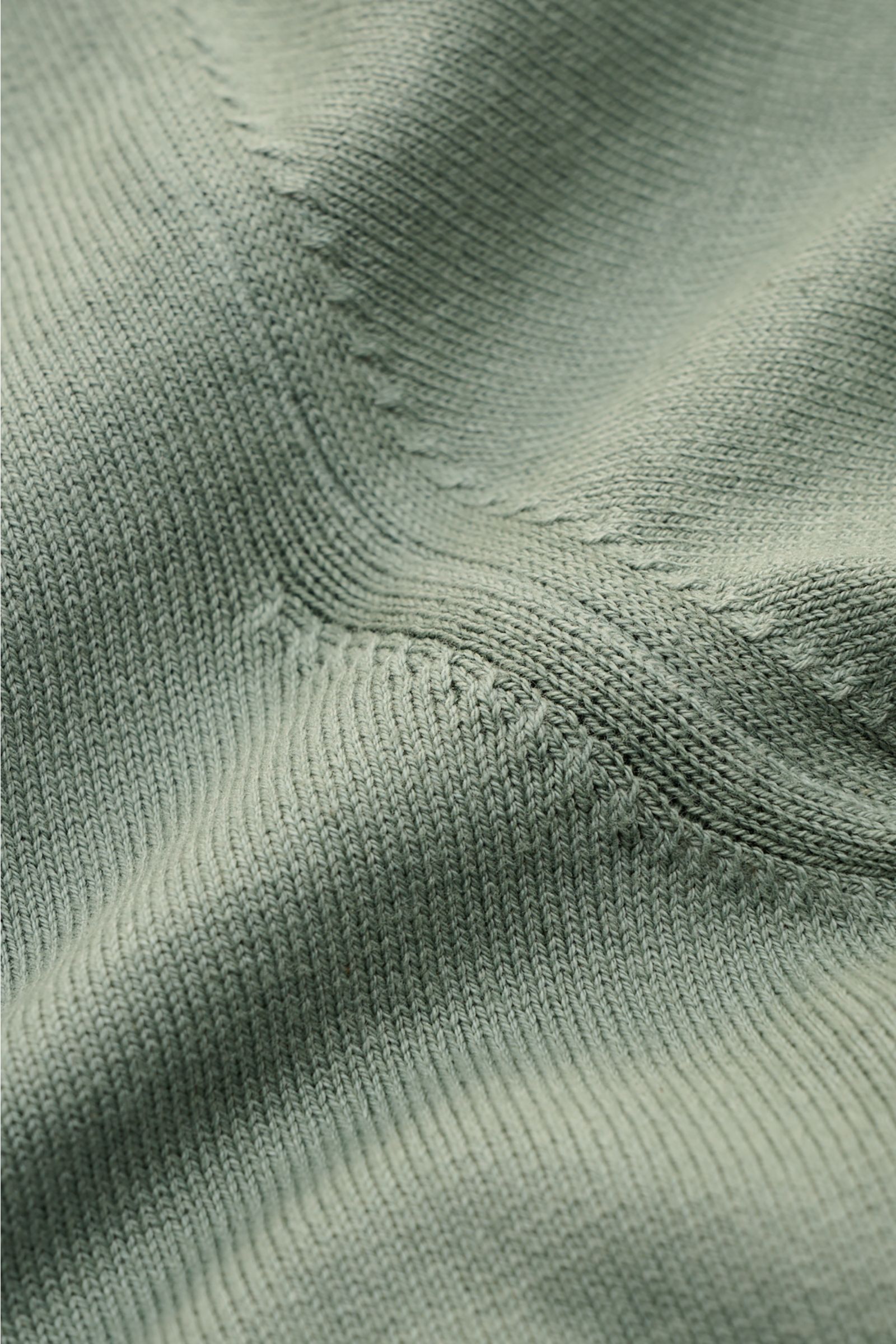 Nahaufnahme des feinen Strickbilds des graugrünen Altea Kurzarm-Strickpolos aus reiner Baumwolle mit weichem Griff.