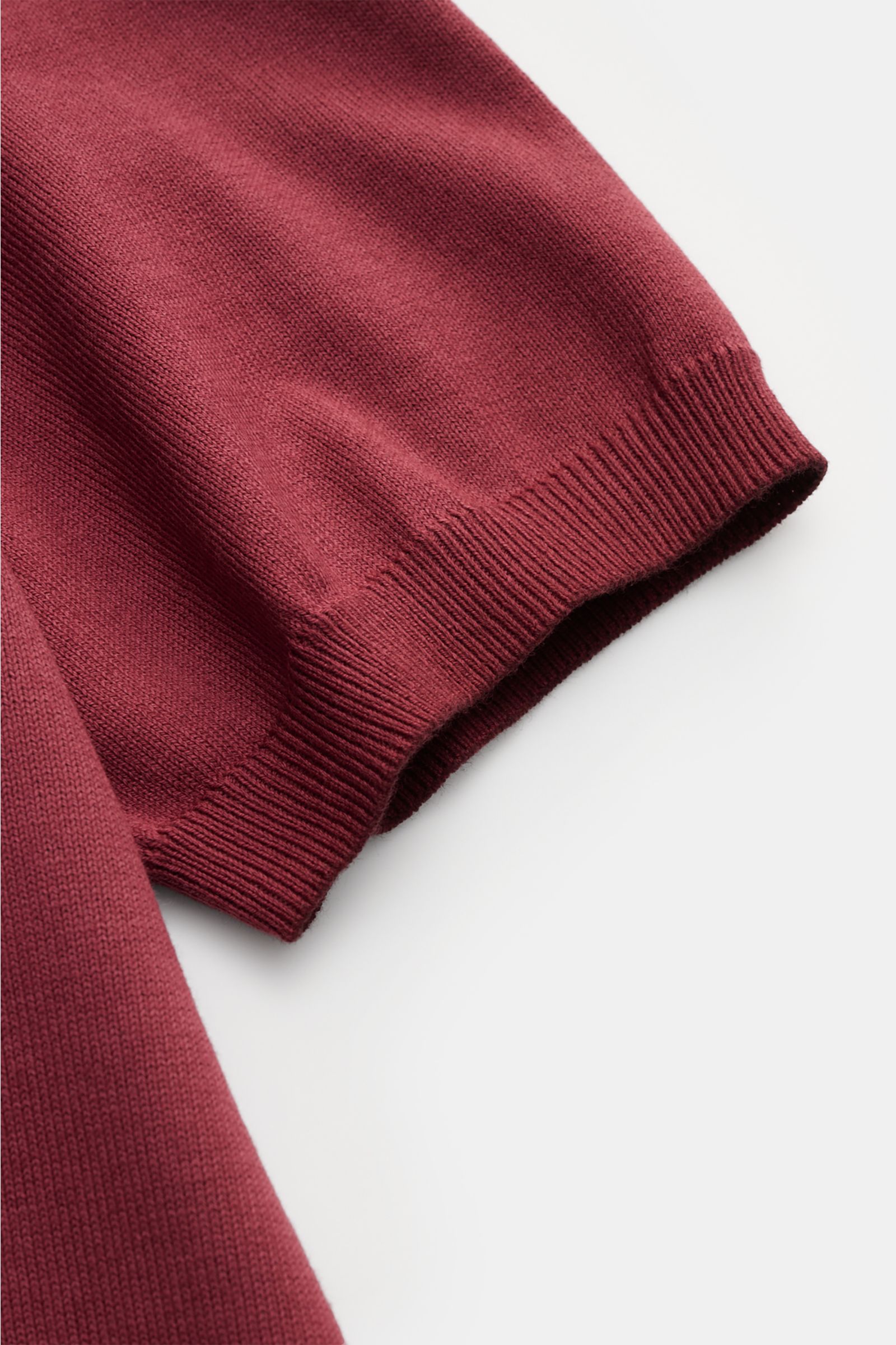 Nahaufnahme des Altea Kurzarm-Strickpolo bordeaux in Slim Fit, reine Baumwolle mit weichem Griff, feinem Strickbild und Rippbündchen.