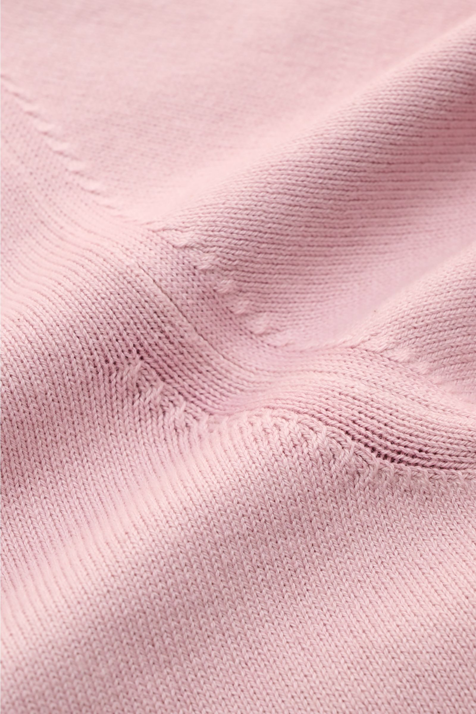 Nahaufnahme des weichen, feinen Strickbilds vom Altea Kurzarm-Strickpolo rosé, Perspektive von oben auf reine Baumwolle, Slim Fit mit klassischem Polokragen, offener Kragenleiste und komfortablen Rippbündchen, vielseitiges Essential für Frühling und Somme