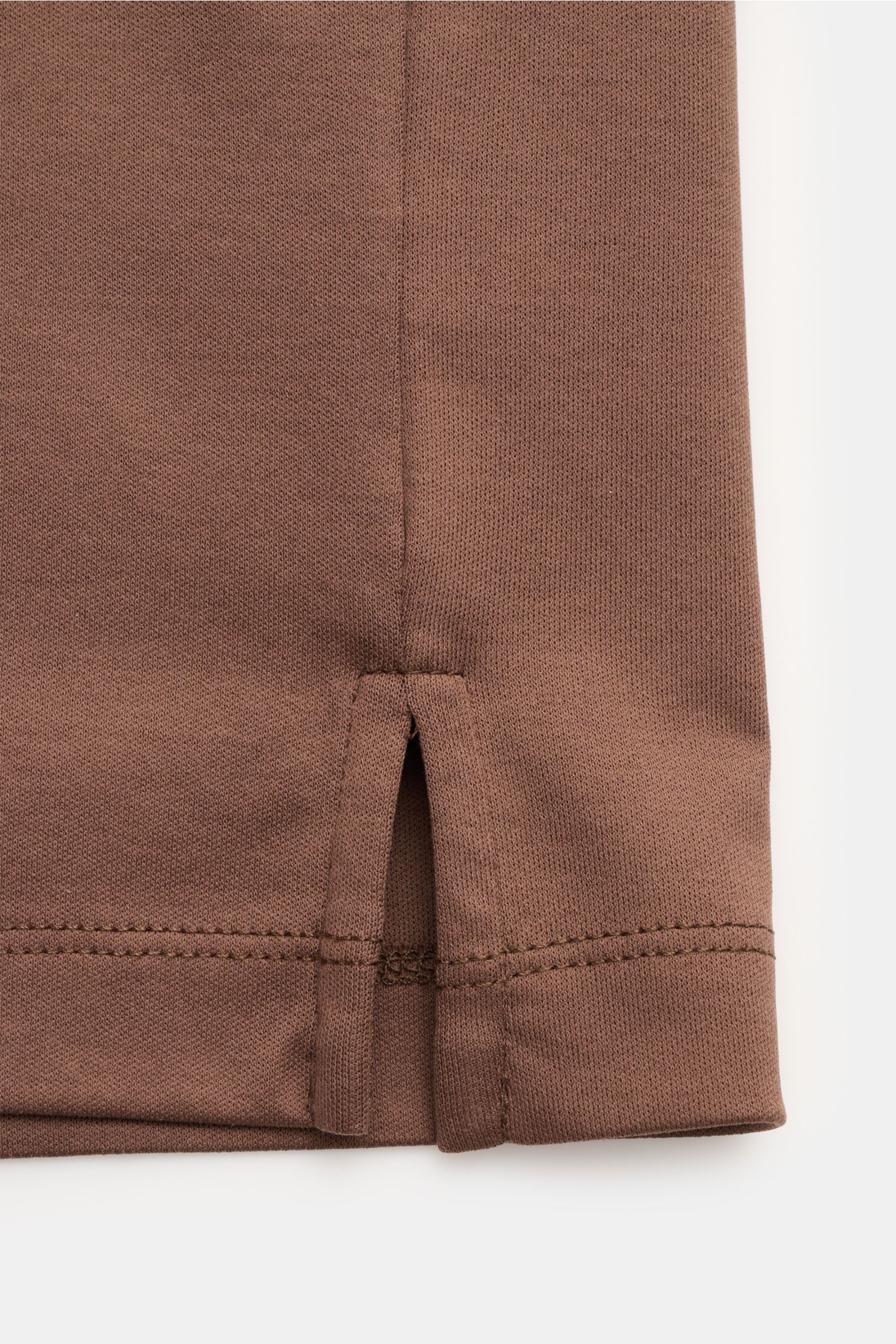Nahaufnahme des kurzen Saums mit Saumschlitz des braunen Aurélien Jersey-Poloshirts aus reiner Baumwolle, glatter Griff.