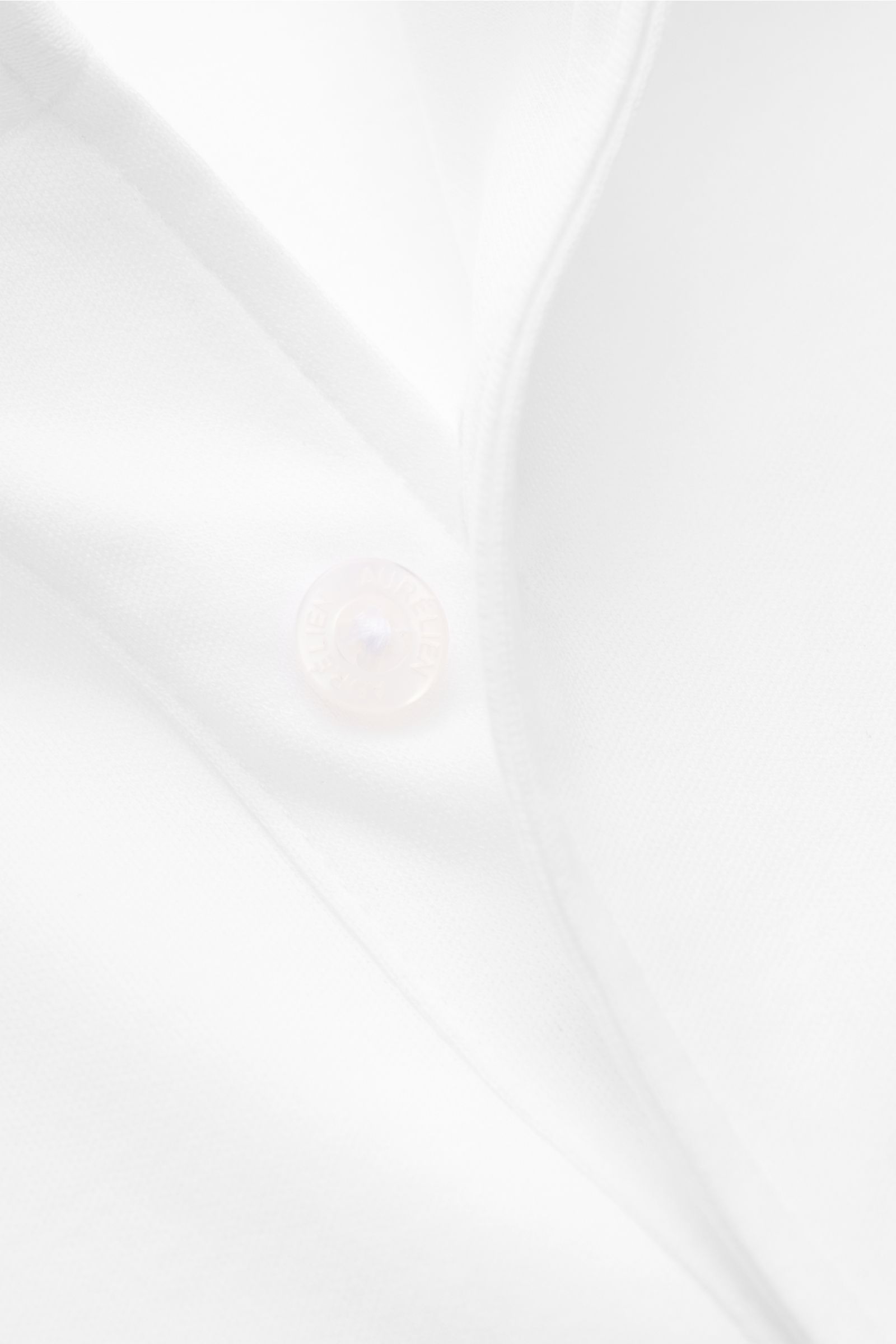 Close-up front view of the Aurélien Jersey-Poloshirt weiß, showing the slim fit, pure cotton fabric, smooth cool touch, tailored polo collar, three-button placket, and short hem slits; versatile basic for spring and summer made from long-staple Egyptian c