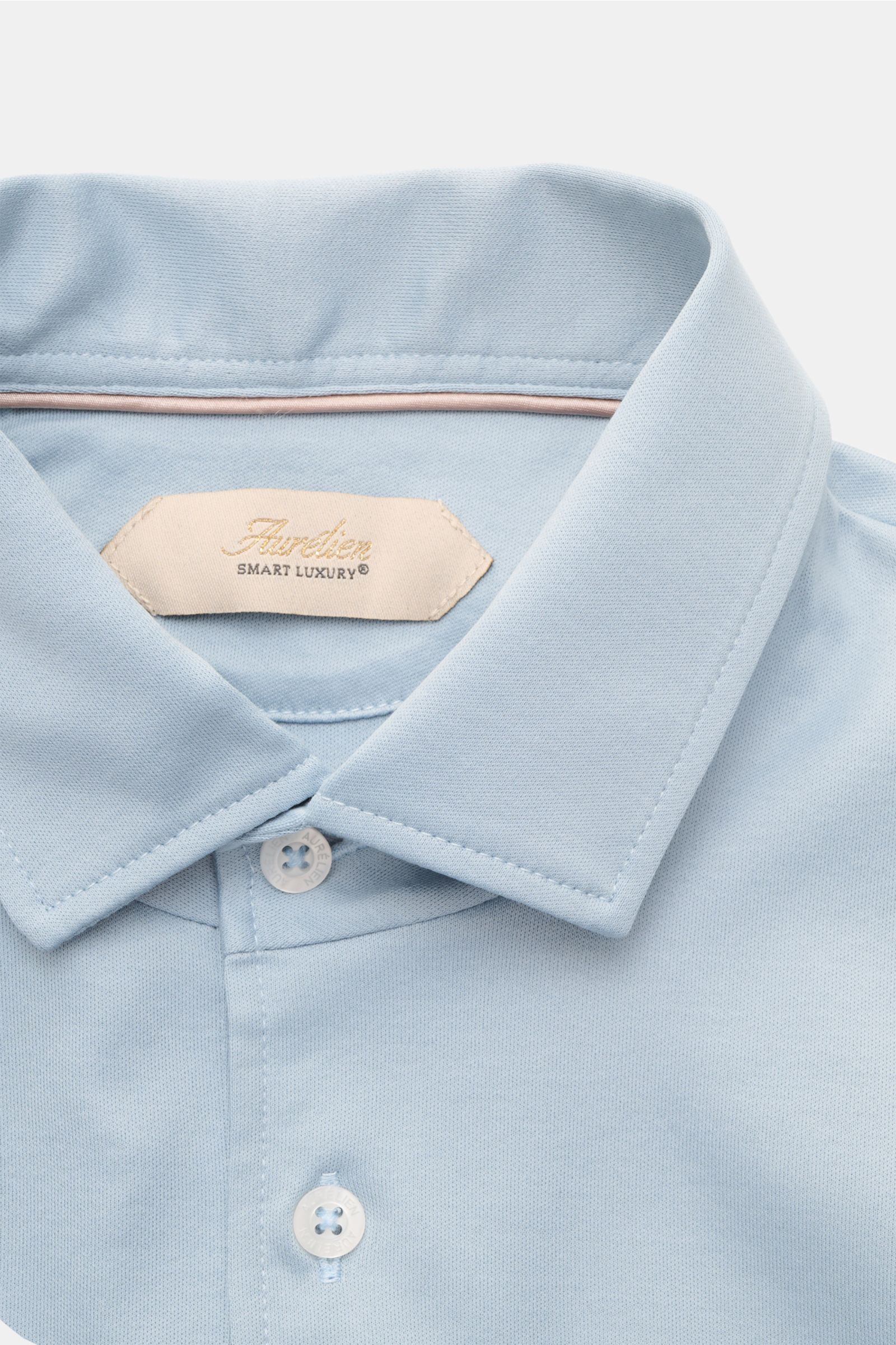 Close-up front view of Aurélien Jersey-Poloshirt hellblau showing slim fit, pure cotton fabric, smooth cool touch, tailored collar, three-button placket, and short hem slits.