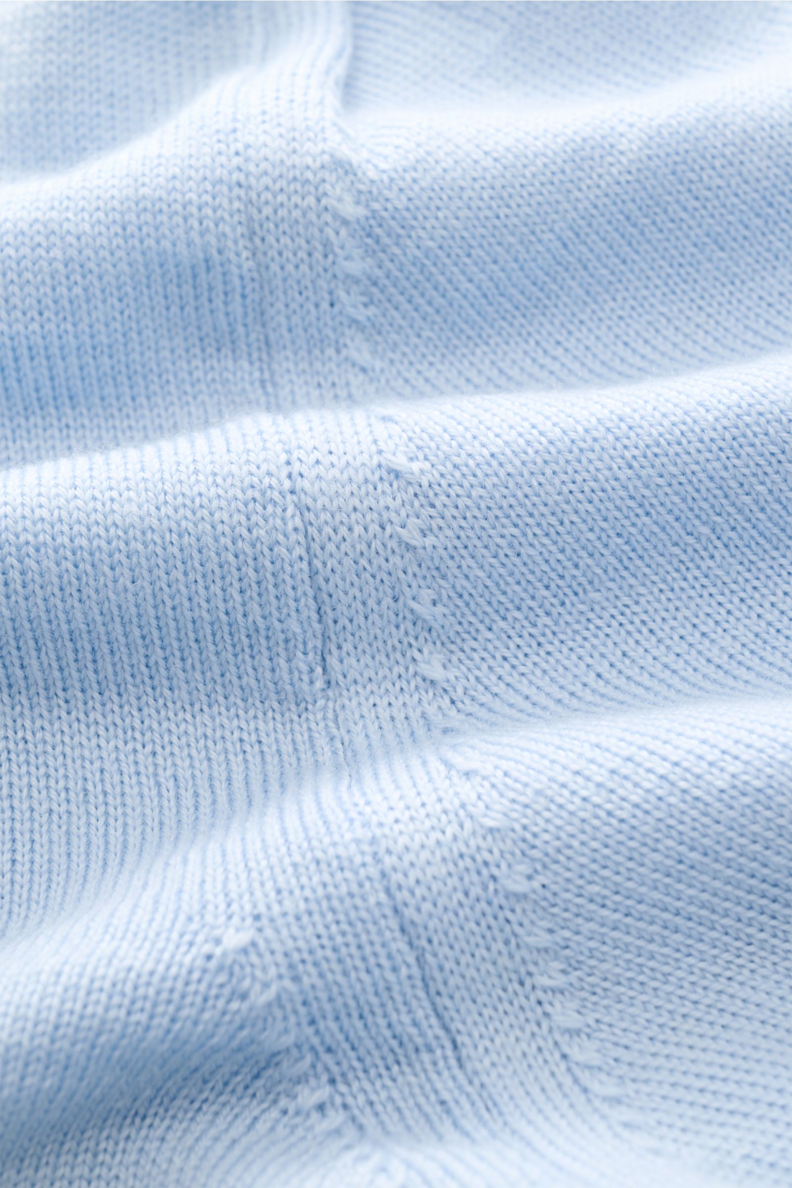 Close-up front view of Aurélien Kurzarm-Strickpolo 'Cashwool' hellblau showing fine knit texture, soft light blue Merino wool fabric, and detailed stitching. Frühlings-Essential: Das Kurzarm-Strickpolo von AURÉLIEN aus exklusiver 'Cashwool'-Merinowolle ve